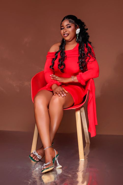 Elegant Woman in Red Dress Seated Indoors · Free Stock Photo