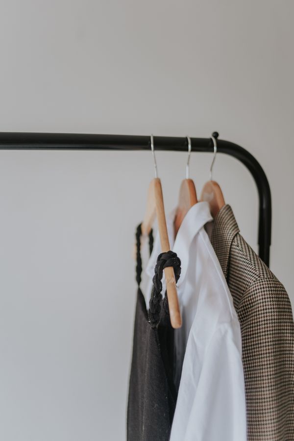 Neutral garments on a slim clothing rail — photo by Letícia Alvares on Pexels