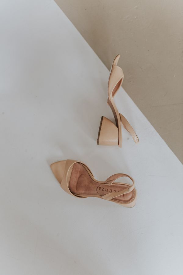 Beige heeled sandals on a minimalist backdrop — photo by Letícia Alvares on Pexels