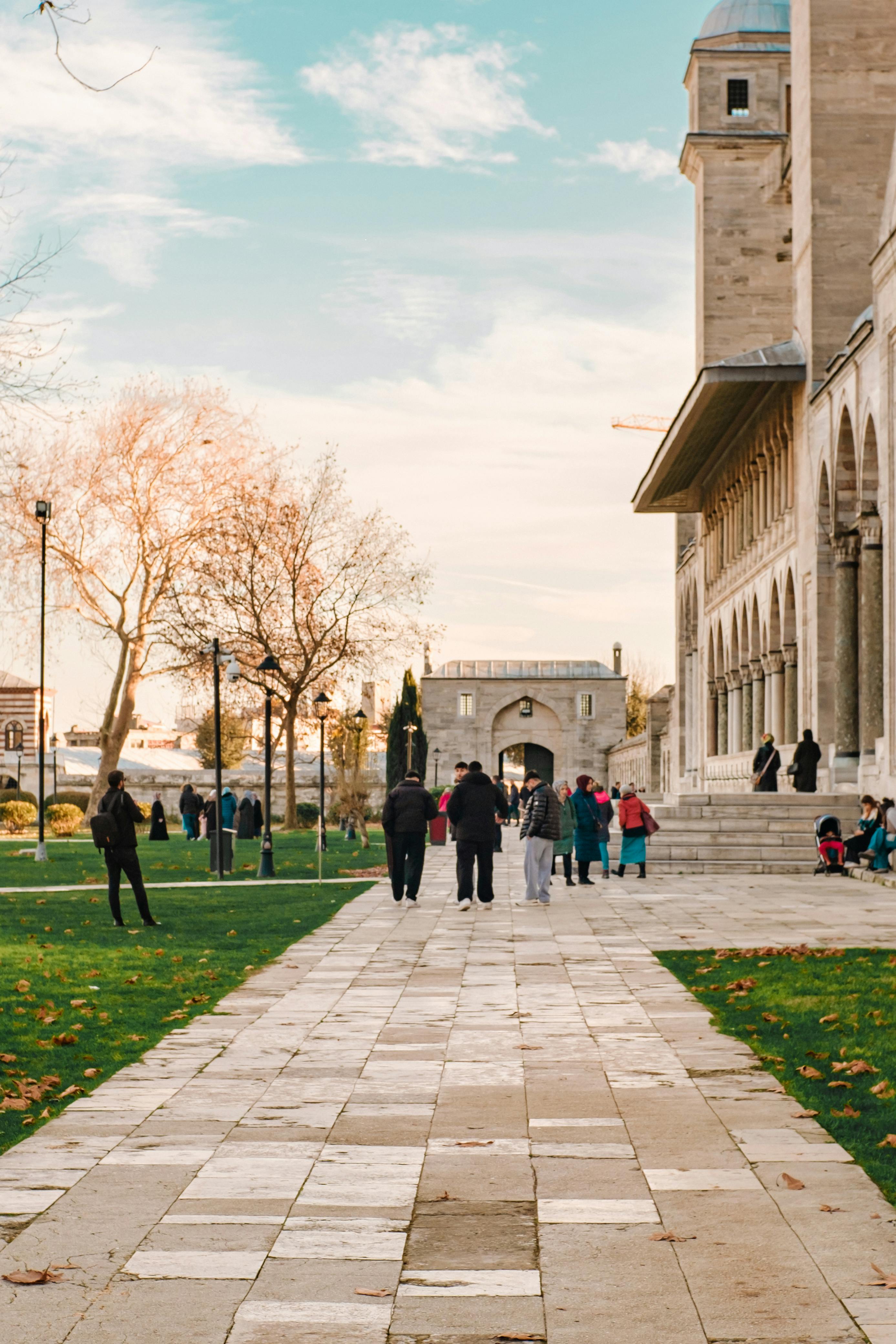 Kostnadsfria Människor som går på en stig bredvid en historisk stenbyggnad på hösten. Stock foto