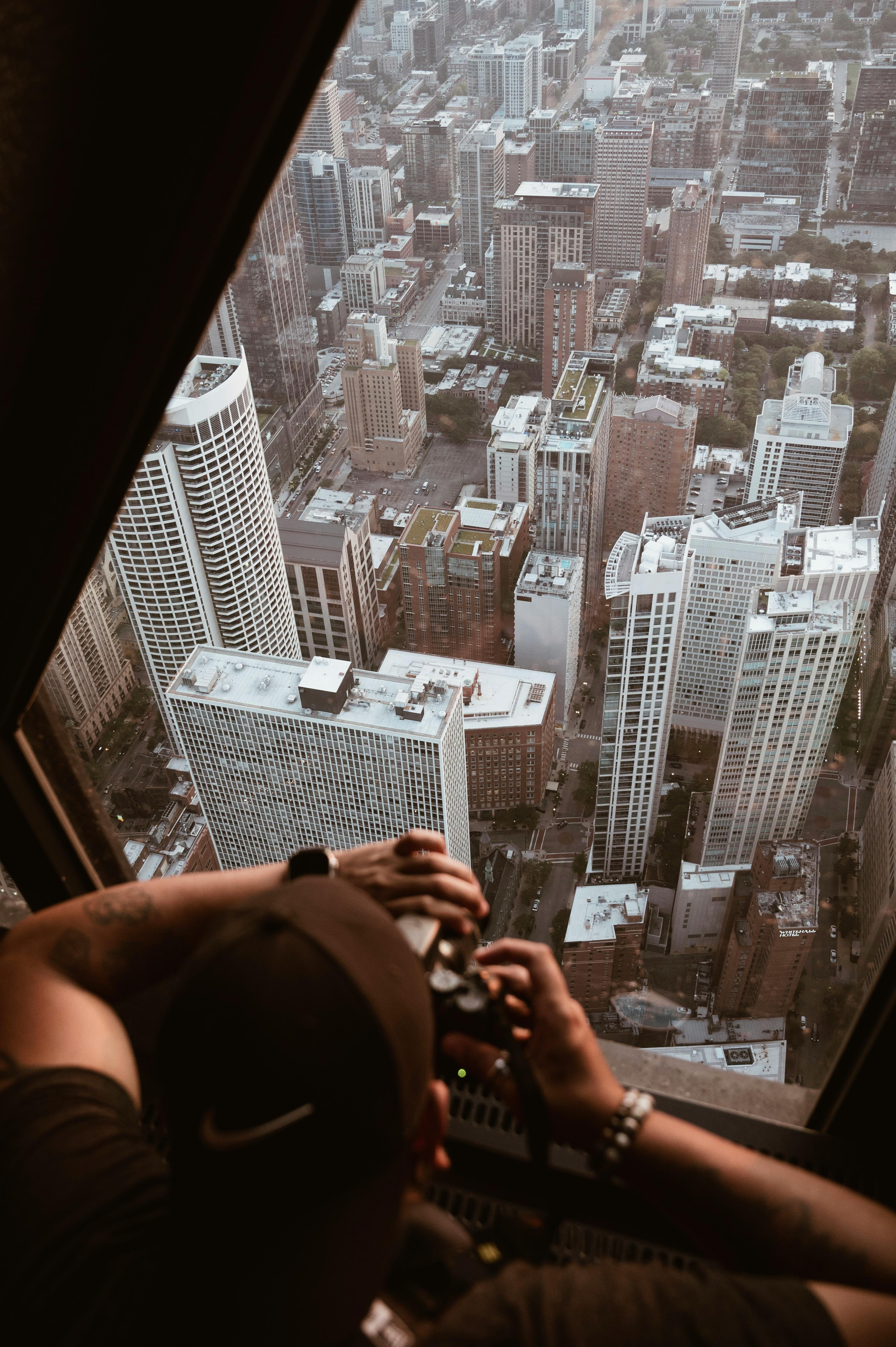 Zadarmo Mestská krajina s fotografom zachytávajúcim mrakodrapy z vysokého miesta. Fotka z fotobanky