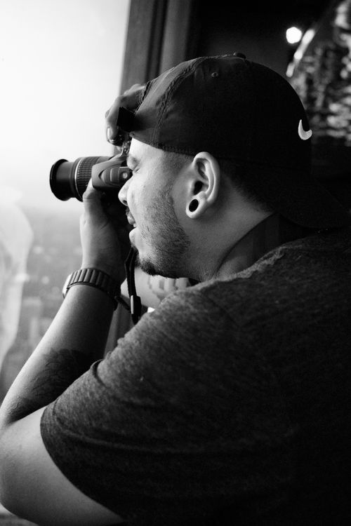 Free Monochrome image of a male photographer taking a picture indoors. Stock Photo
