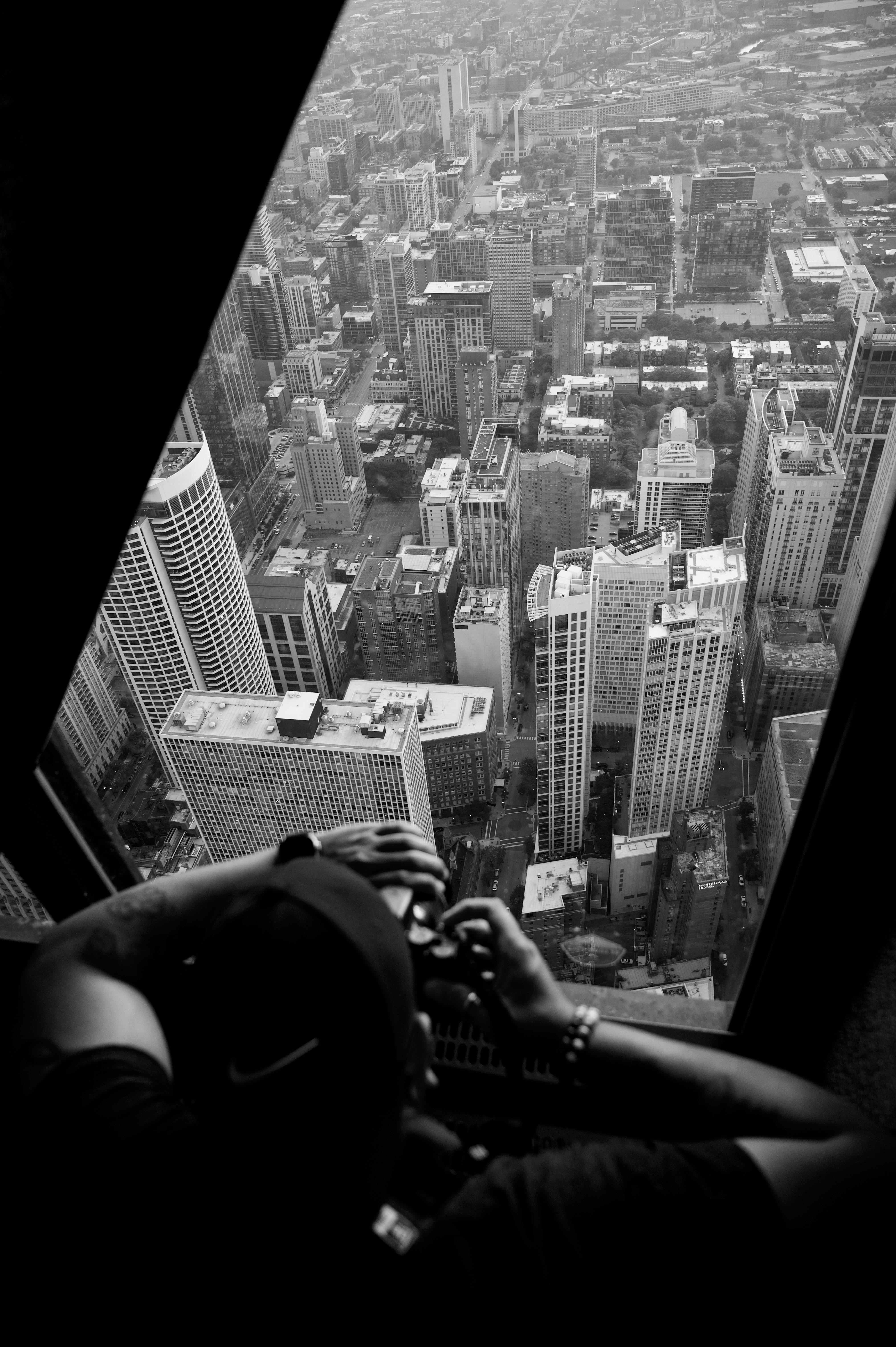 bezplatná Podmanivá černobílá letecká fotografie zachycující osobu fotografující mrakodrapy. Základová fotografie