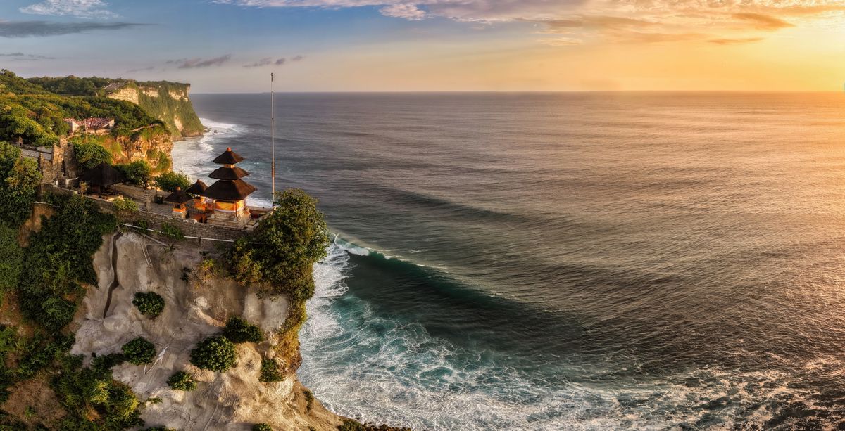 Uluwatu Temple Bali on a dramatic cliff above the ocean at sunset