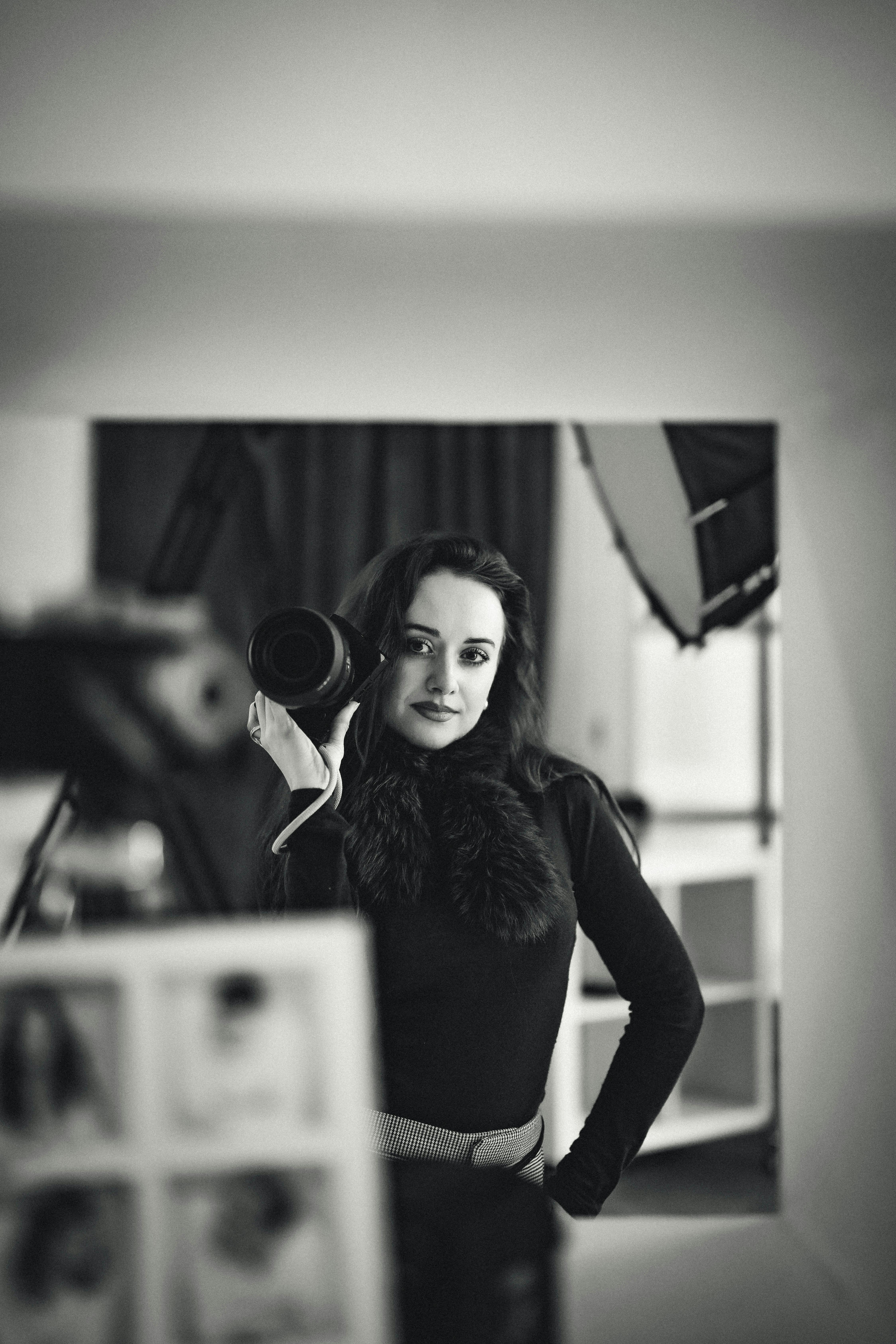 Zadarmo Čiernobiely obraz fotografky s fotoaparátom v štúdiu. Fotka z fotobanky