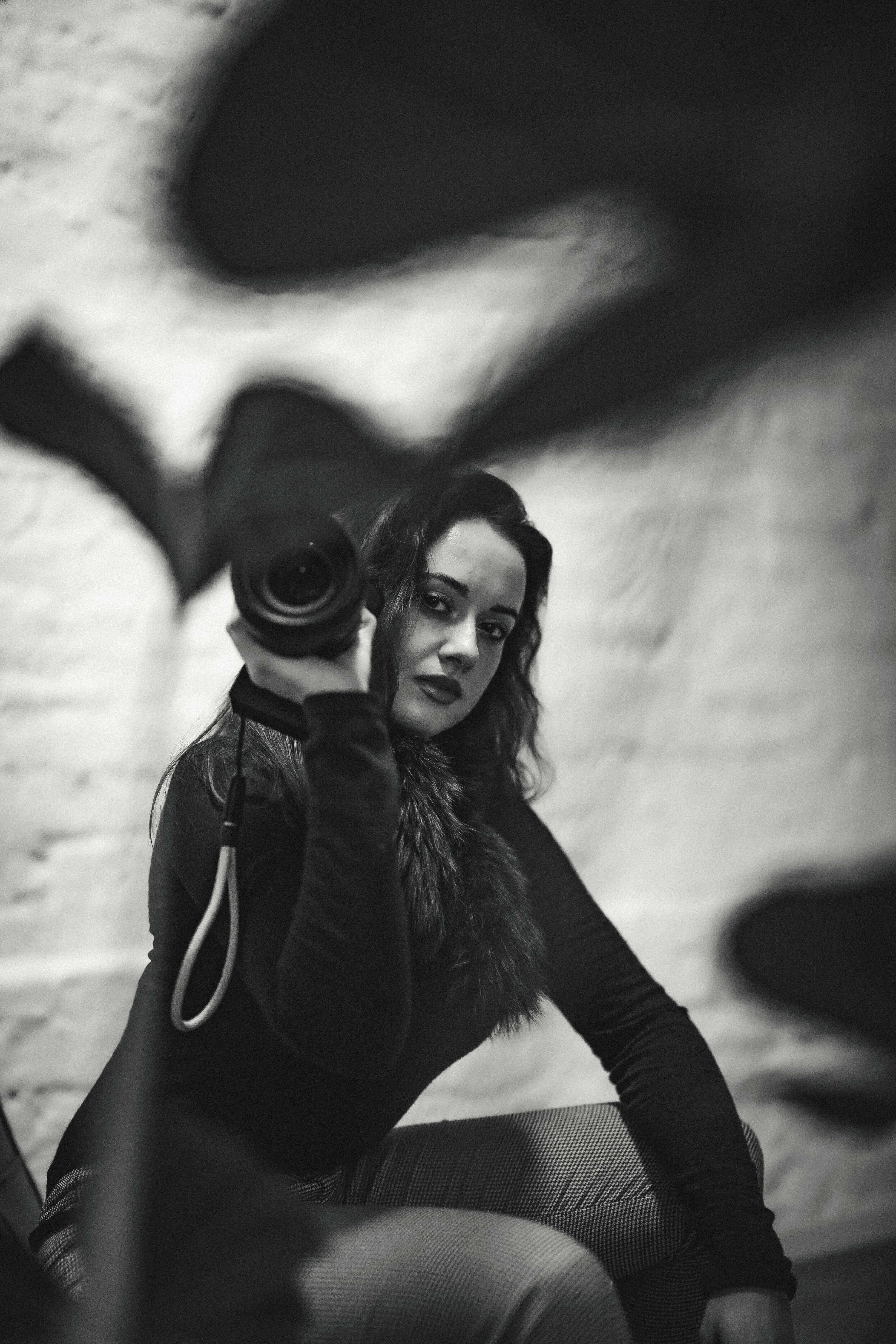 bezplatná Podmanivý černobílý portrét ženy s fotoaparátem v Düsseldorfu. Základová fotografie