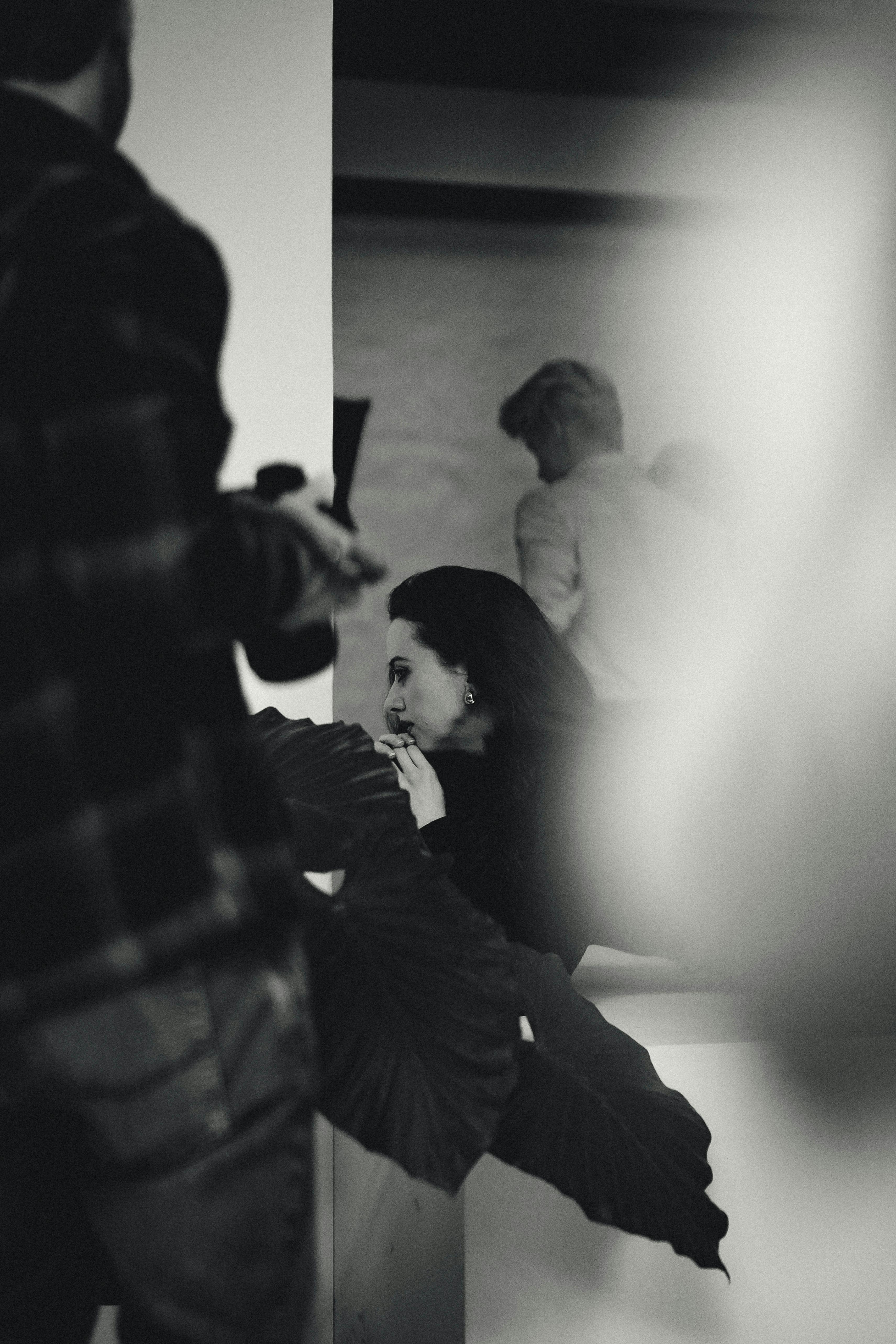 ingyenes Fekete-fehér, őszinte jelenet, amely embereket örökít meg művészi beltéri környezetben. Stockfotó