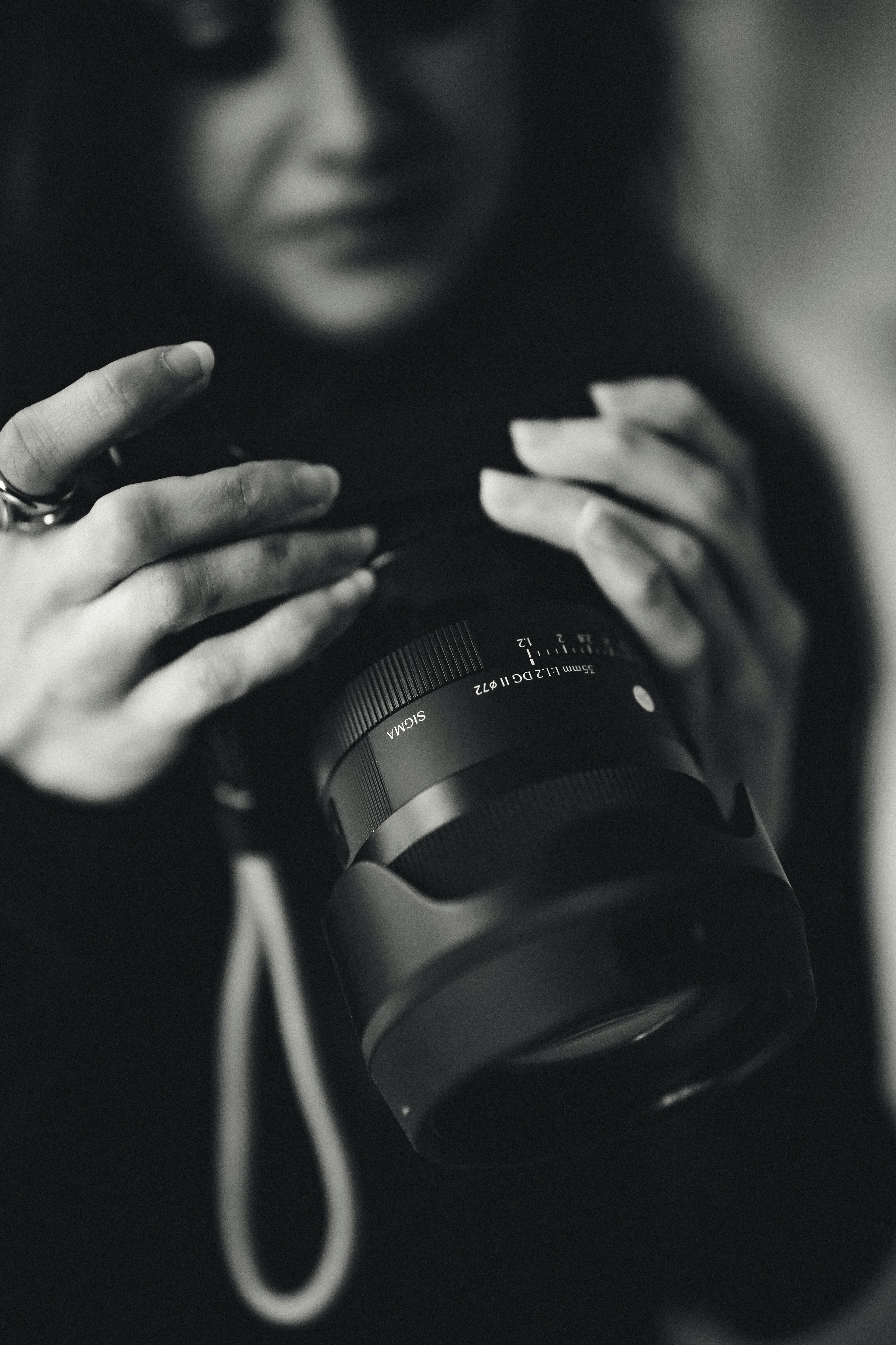 Zadarmo Umelecká čiernobiela fotografia fotografa skúmajúceho objektív fotoaparátu. Fotka z fotobanky