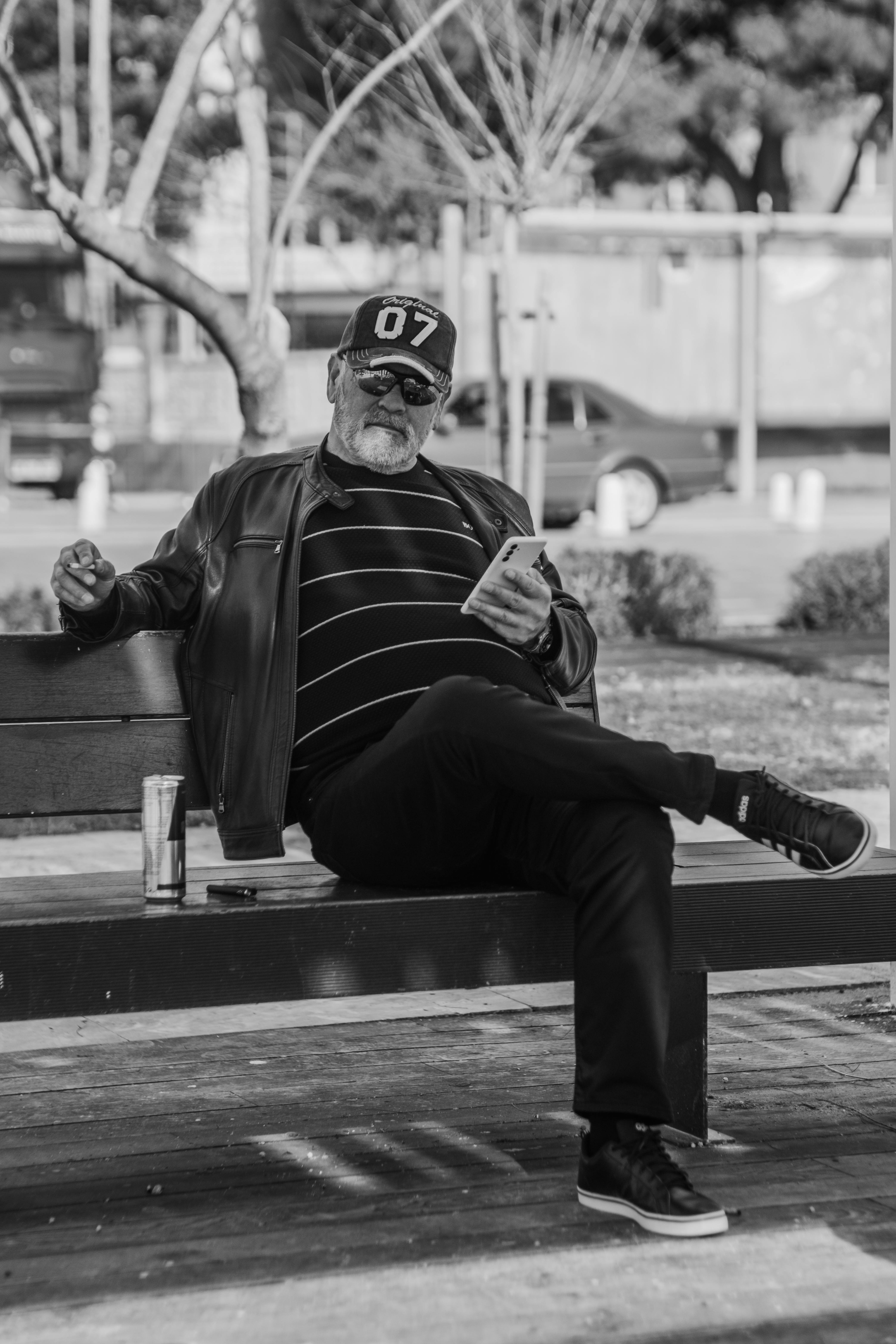 Zadarmo Senior muž sedí na lavičke v parku a číta knihu, stelesňujúc tak oddych a pokoj v mestskom prostredí. Fotka z fotobanky