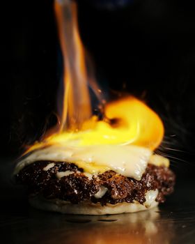 Close-up of a gourmet burger with melted cheese, flame-grilled to perfection.