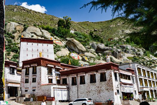 Ancient Buddhist monastery set against a rocky mountain backdrop, illustrating beautiful Tibetan architecture.