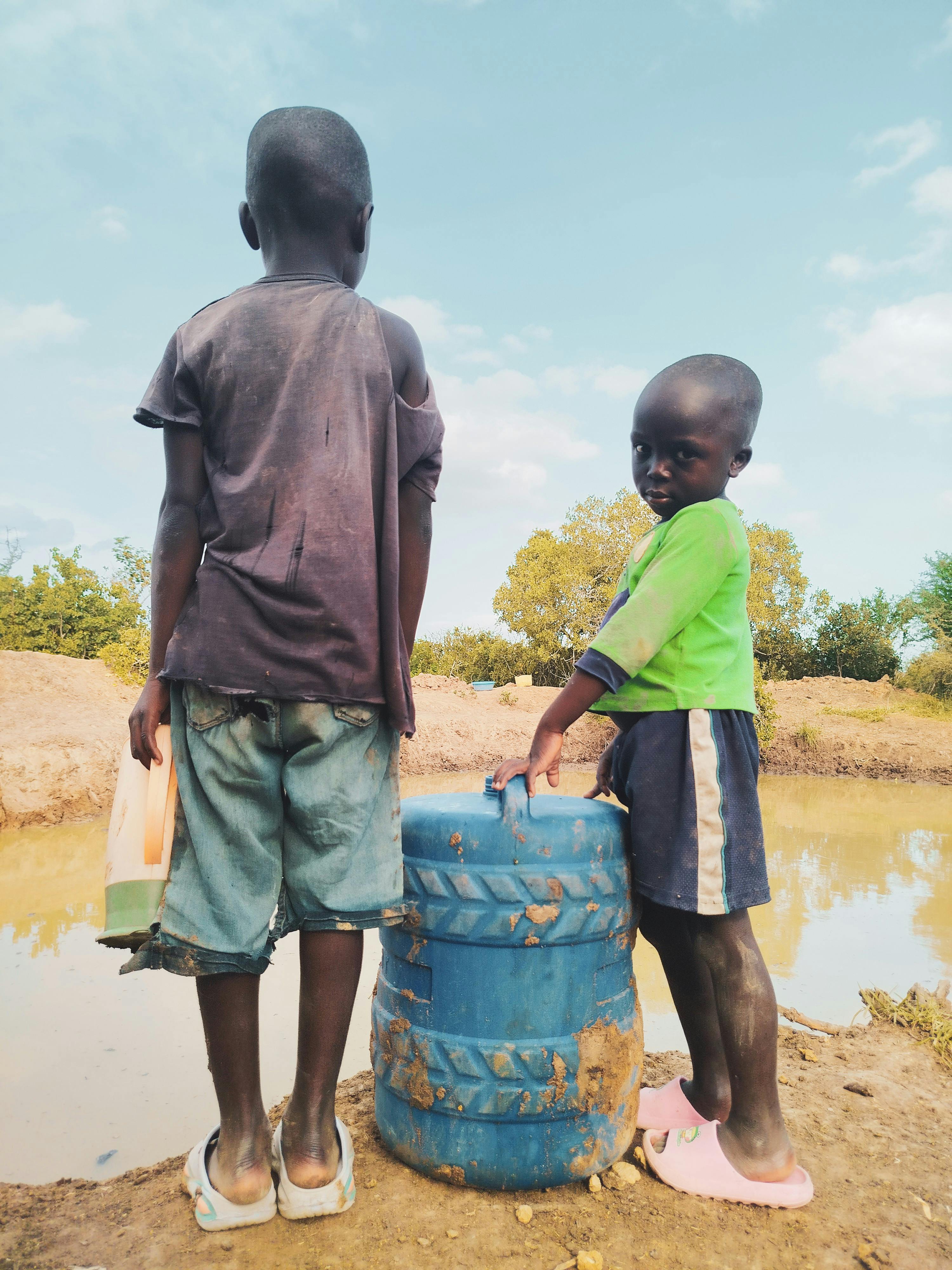 Bezpłatne Dwoje dzieci zbiera wodę na wsi, zwracając uwagę na problem niedoboru wody na świecie. Zdjęcie z galerii
