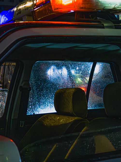 Free Raindrops on a car window with city lights at night create a moody atmosphere. Stock Photo