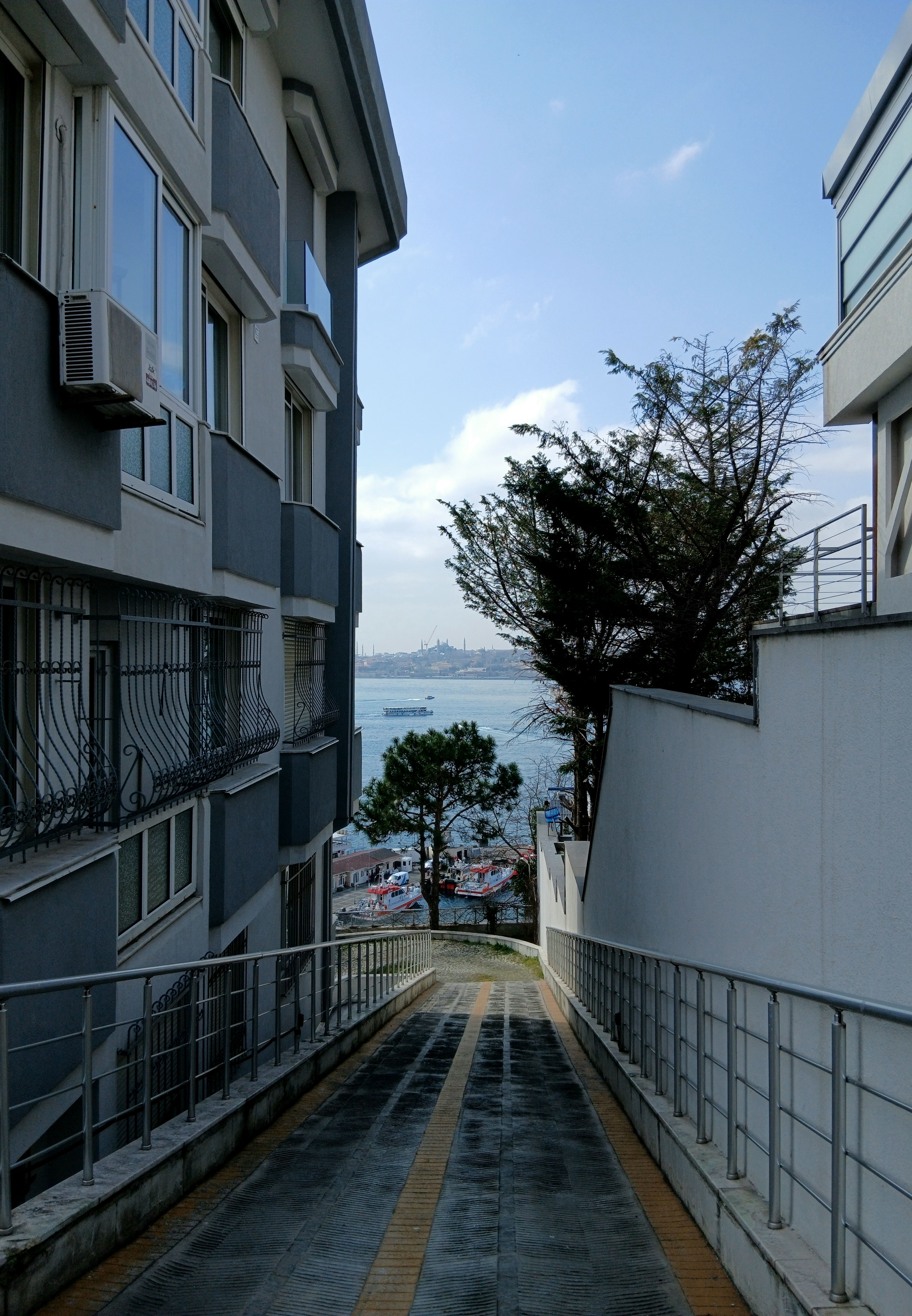 Scenic coastal view between urban buildings · Free Stock Photo