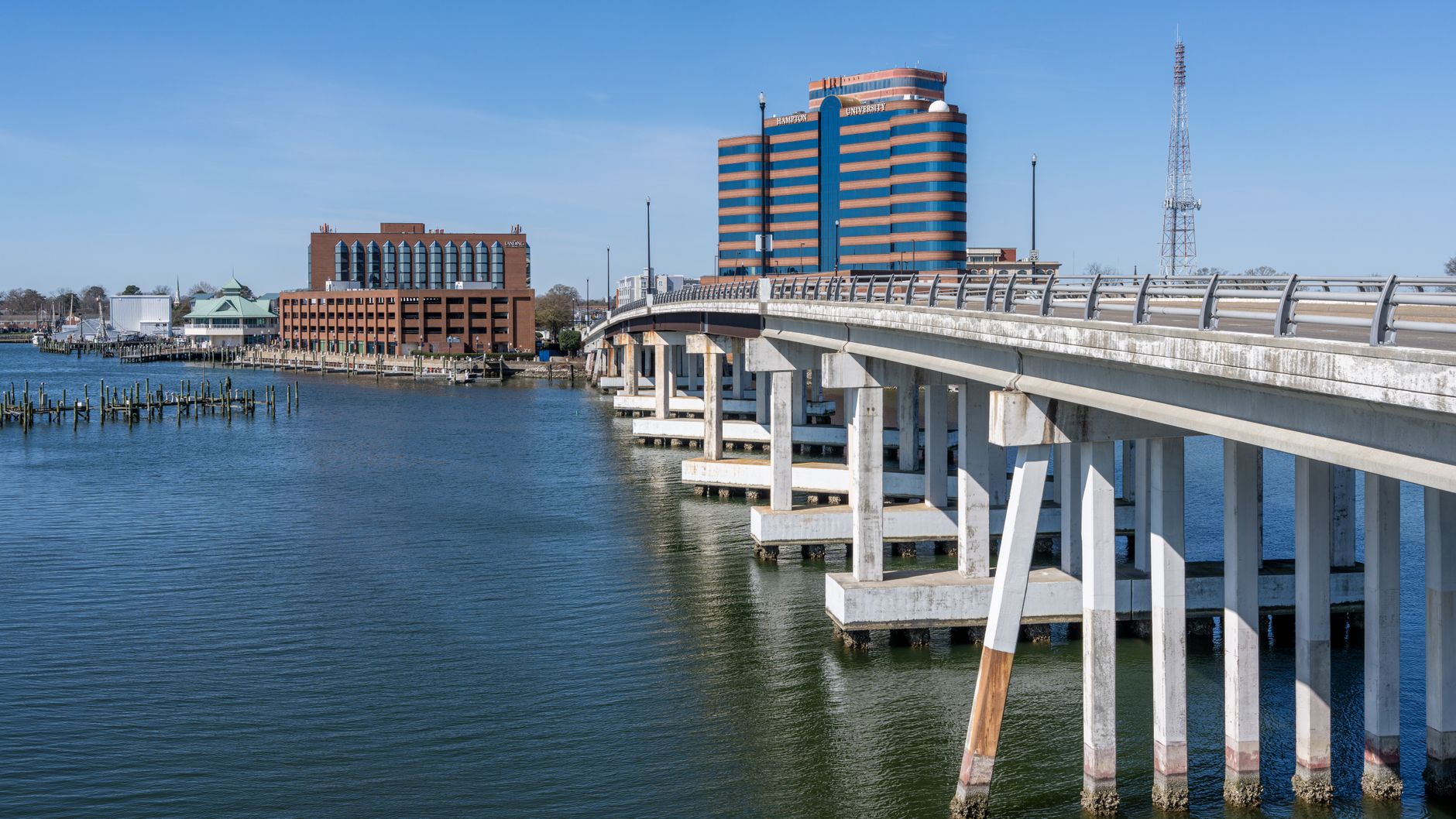 View of Hampton Harbor with prominent bridge and waterfront buildings on a clear day.