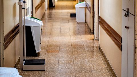 A quiet, empty hospital corridor with medical equipment and a scale.