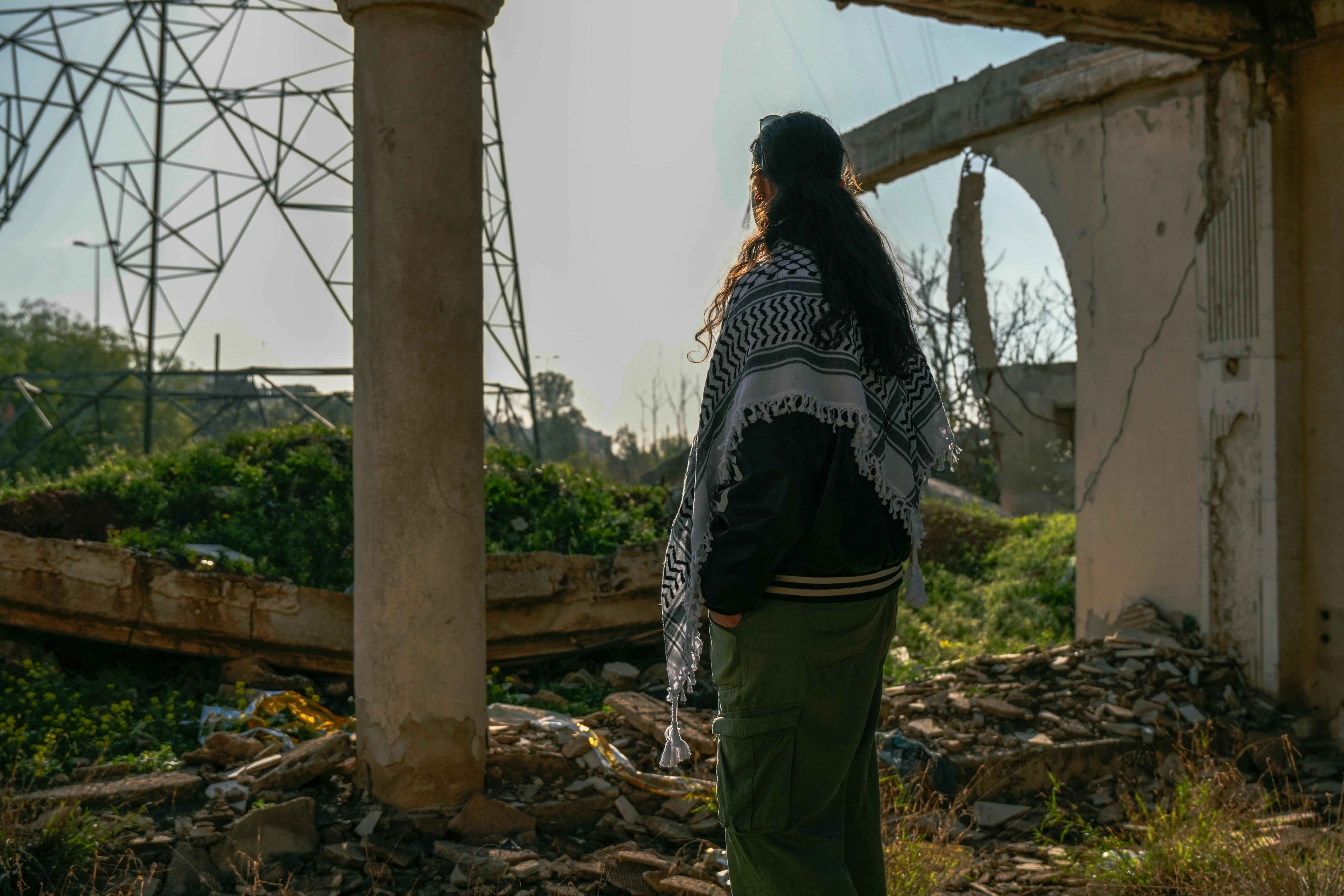 ฟรี หญิงคนหนึ่งยืนอยู่ท่ามกลางซากปรักหักพังในกรุงดามัสกัส ประเทศซีเรีย มองไปยังขอบฟ้า คลังภาพถ่าย