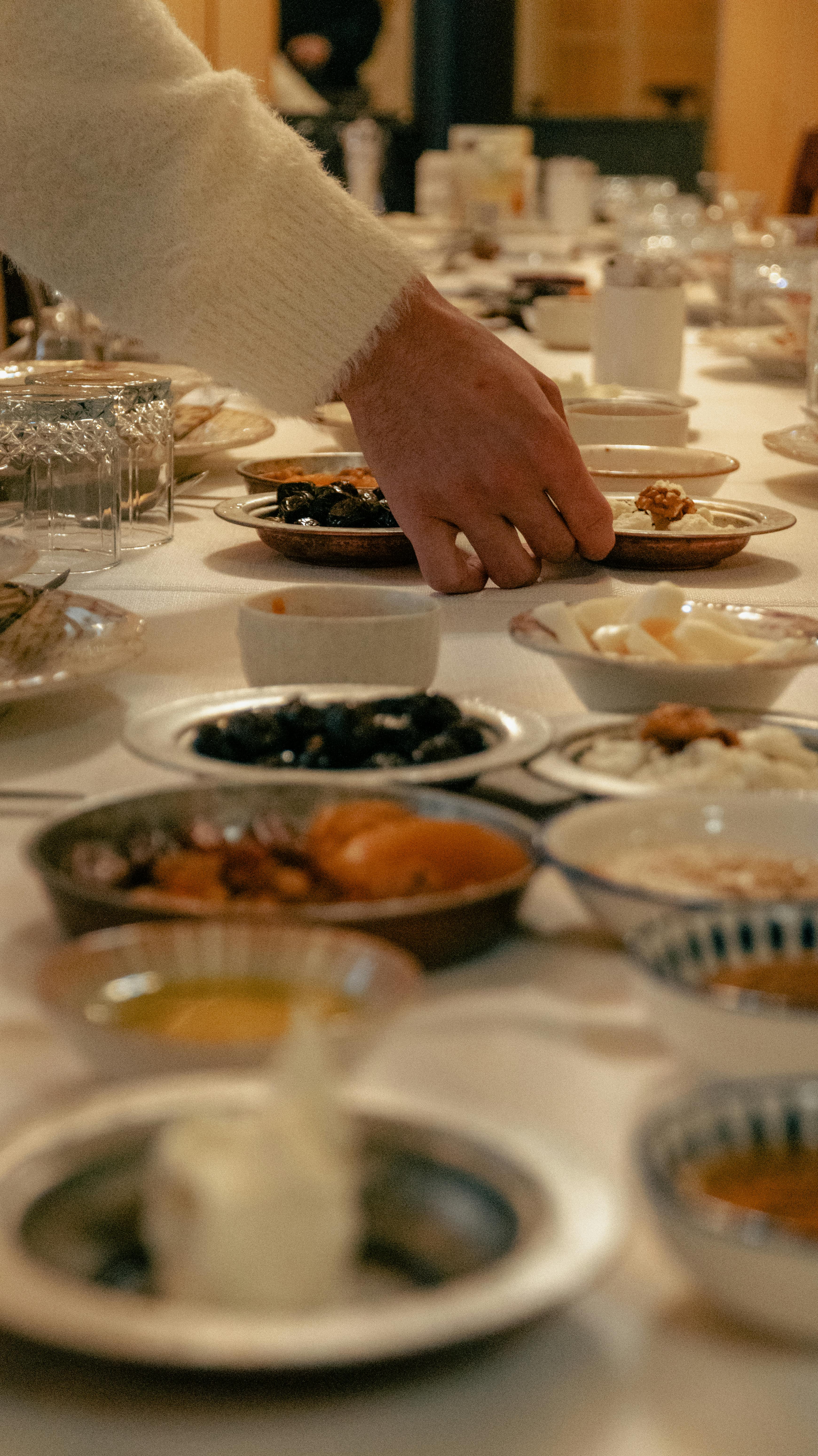 ฟรี มือข้างหนึ่งเอื้อมไปหยิบอาหารบนโต๊ะอาหารเช้าแบบตุรกีโบราณในเมืองกาซิอันเตป ประเทศตุรกี คลังภาพถ่าย