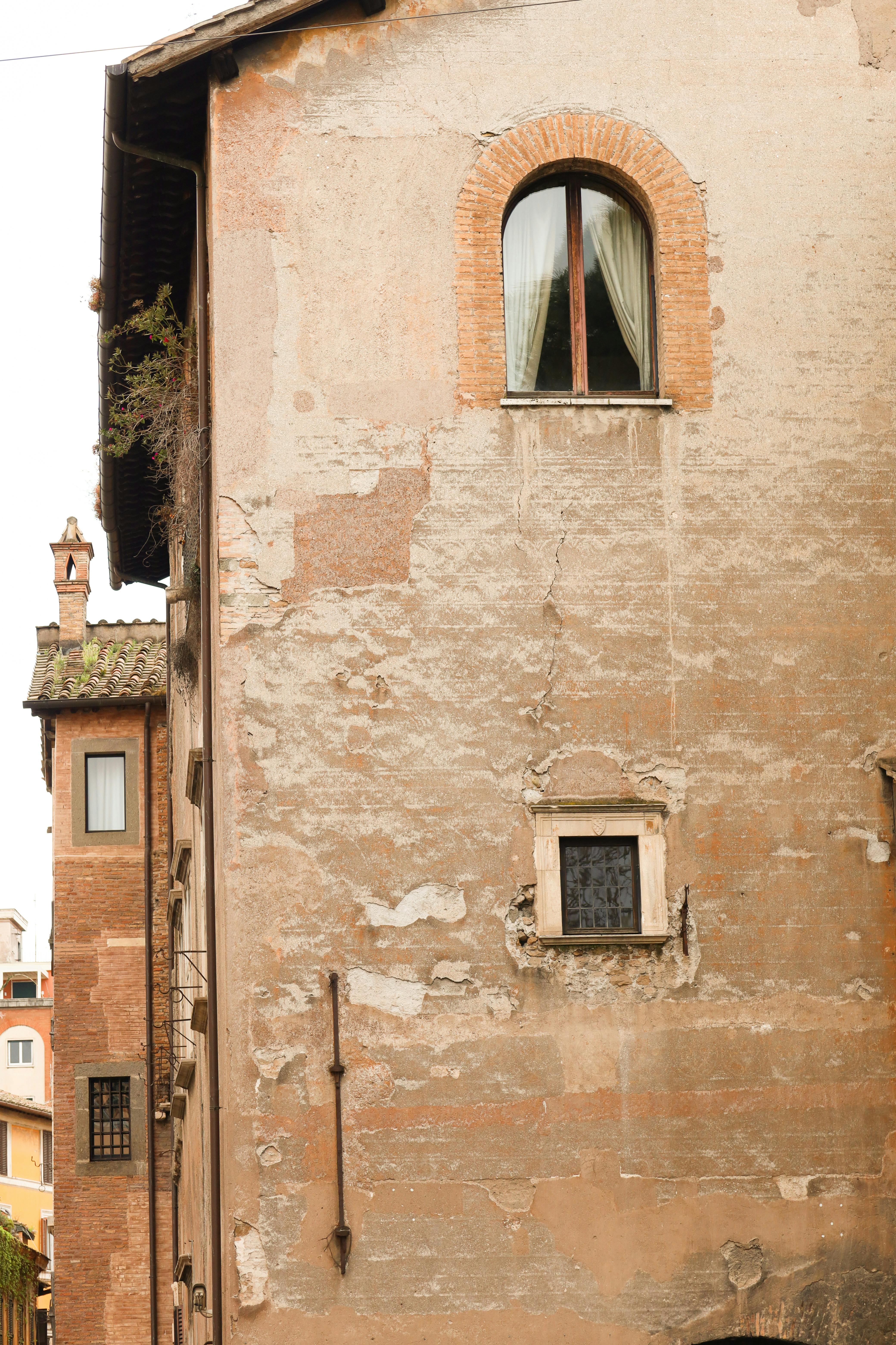 ฟรี สัมผัสความงามเหนือกาลเวลาของสถาปัตยกรรมโรมันโบราณด้วยภาพนี้ ซึ่งแสดงให้เห็นถึงด้านหน้าอาคารที่ผ่านกาลเวลามานานในกรุงโรม ประเทศอิตาลี คลังภาพถ่าย