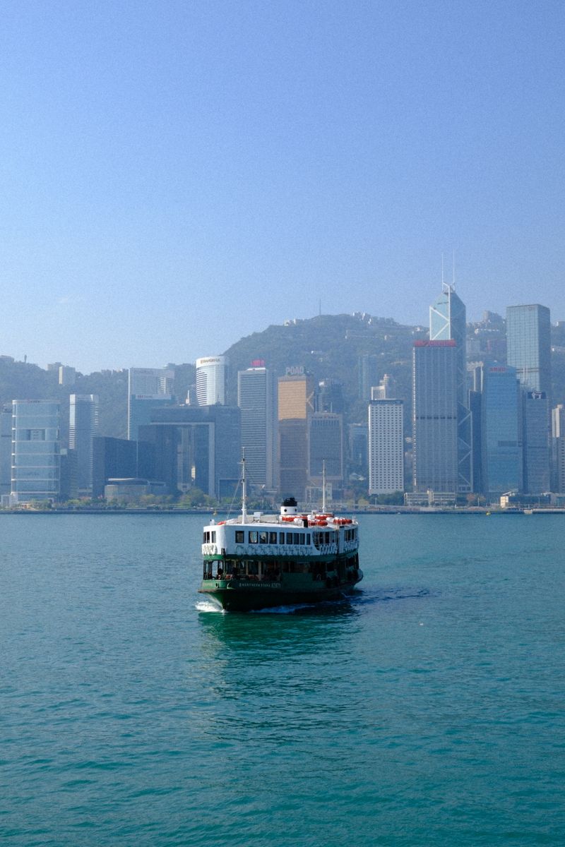 The famous Star Ferry crosses the harbor with Hong Kong's skyline in the background.