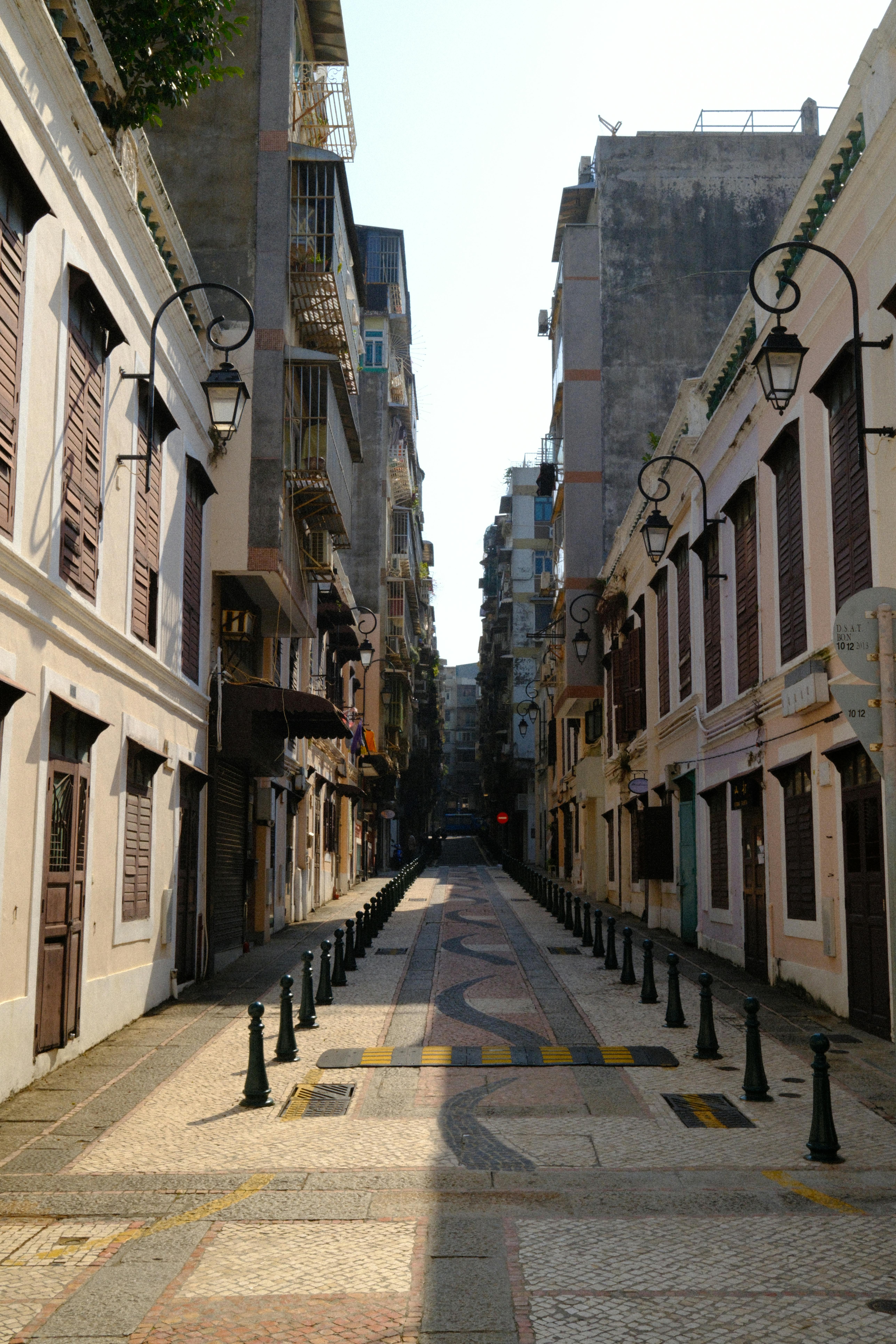 Bezpłatne Malowniczy widok na cichą, historyczną ulicę na Starym Mieście w Makau, ozdobioną klasyczną architekturą i zabytkowymi latarniami ulicznymi. Zdjęcie z galerii