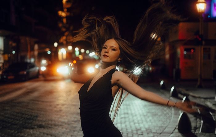 A captivating portrait of a woman dancing at night in a vibrant Buenos Aires street., by Maive & Nahuel Fotografía on Pexels