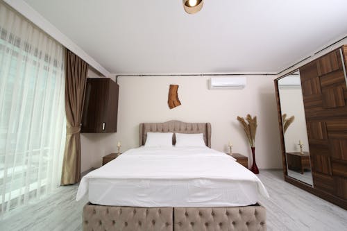 Белое постельное белье с коричневым каркасом кровати