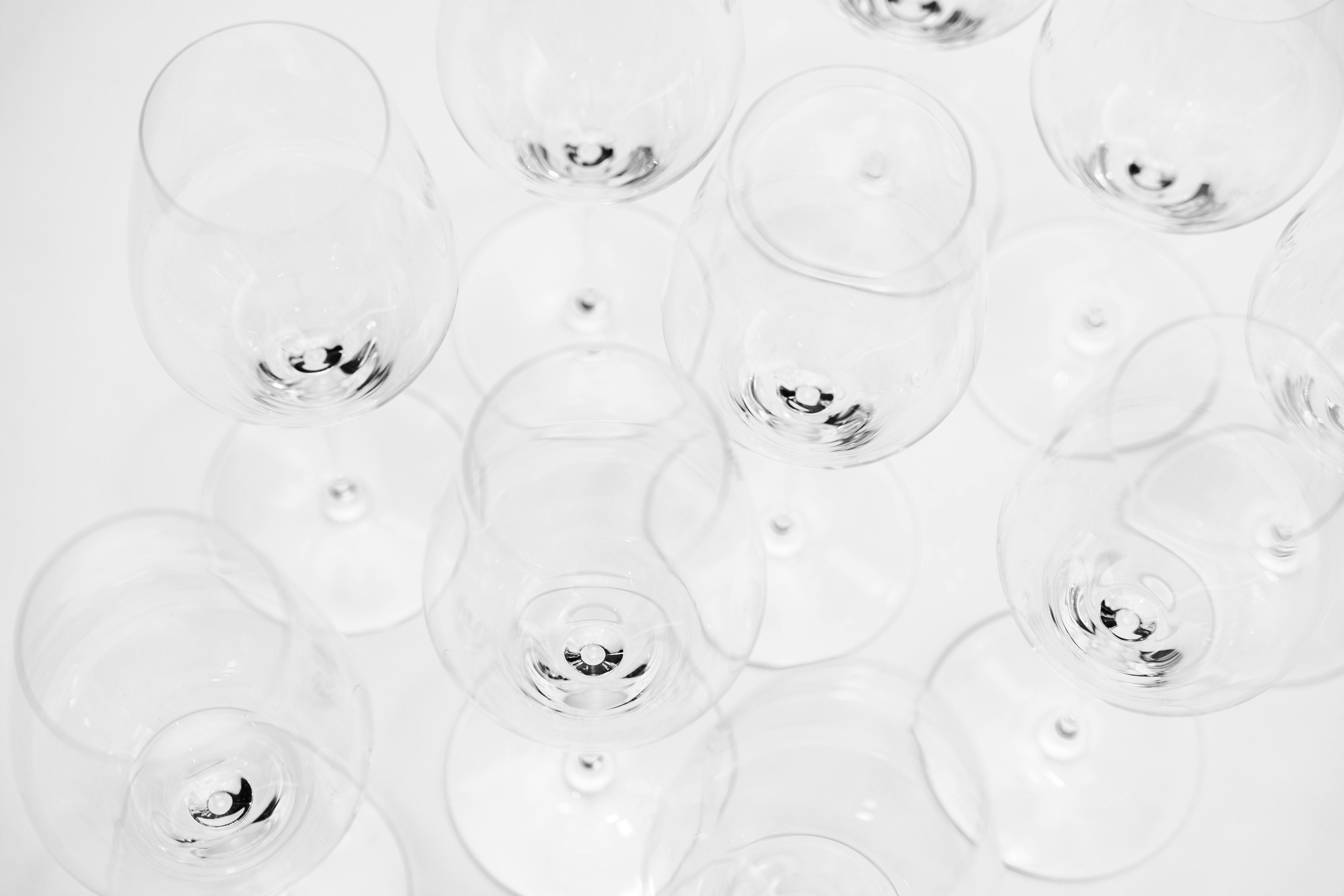 Безкоштовне Художній знімок зверху, що демонструє сучасну вітрину порожніх келихів для вина на білому фоні. стокове фото