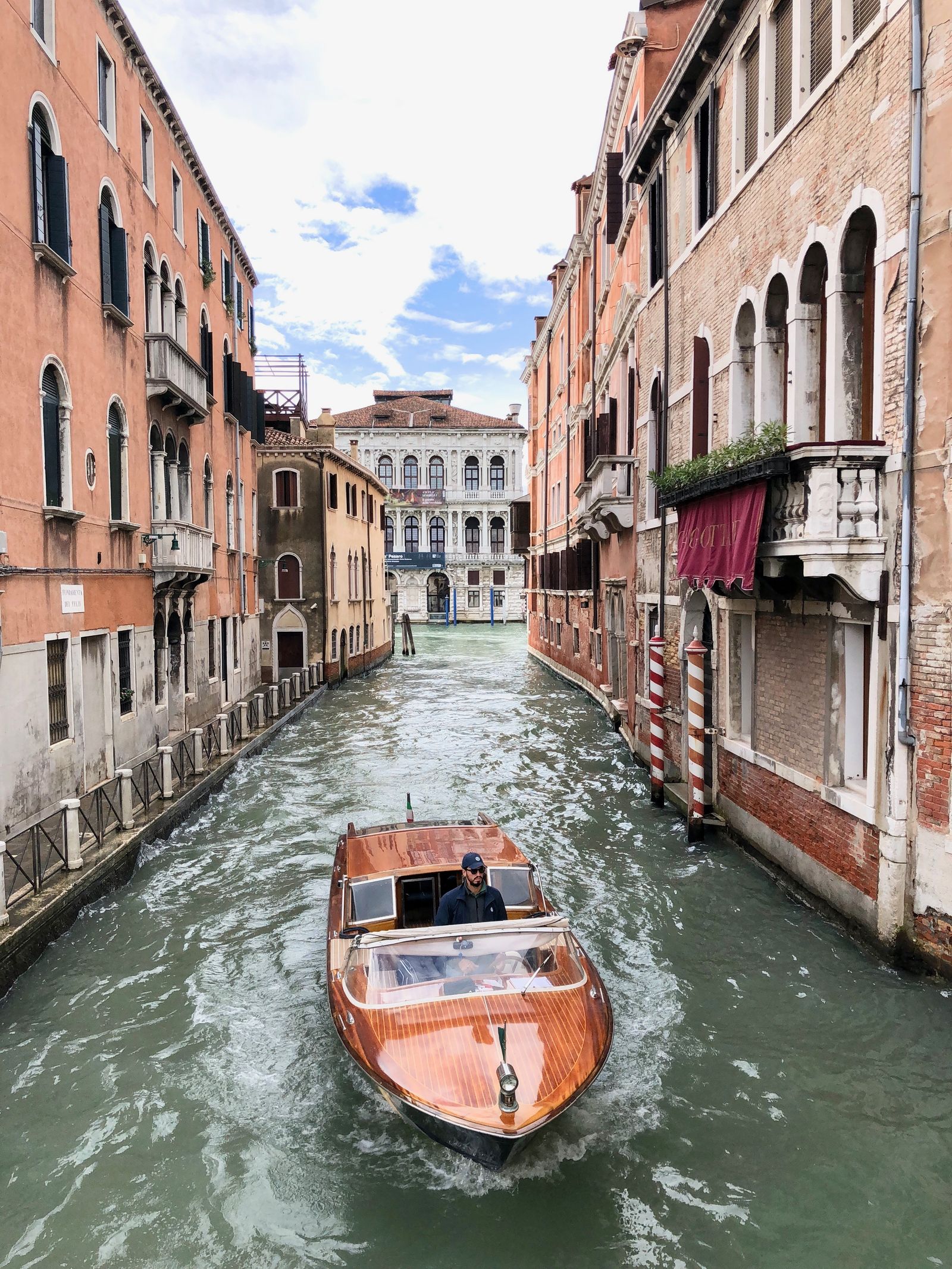 Venice canal with wooden boat and colourful buildings