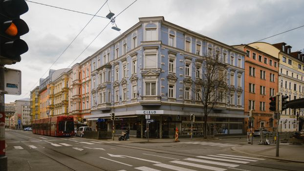 Street view in Innsbruck, Austria with historic buildings and a passing tram.