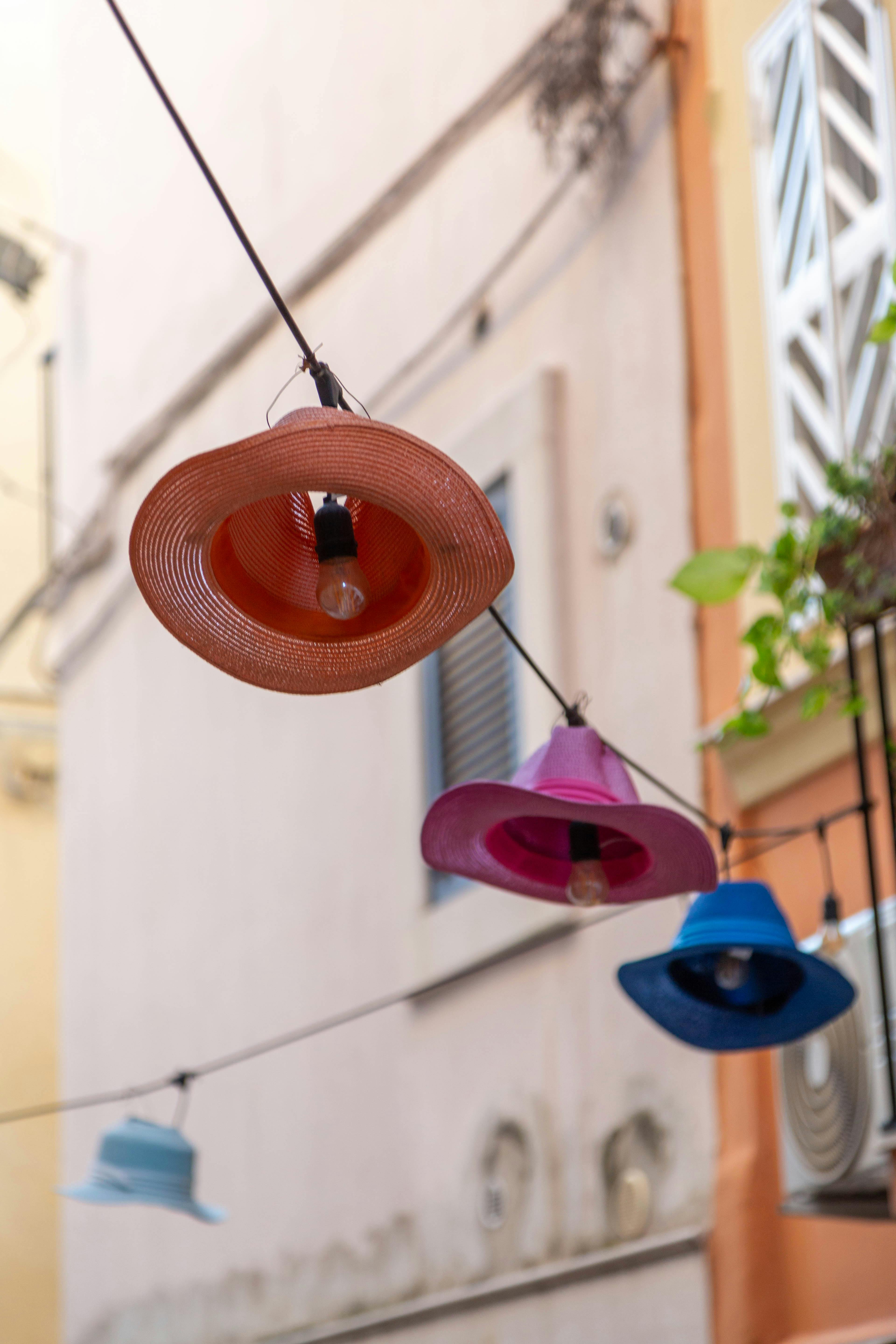 Zadarmo Dekoratívne lampy v tvare klobúka rozvešané cez ulicu v Bari v Taliansku. Fotka z fotobanky