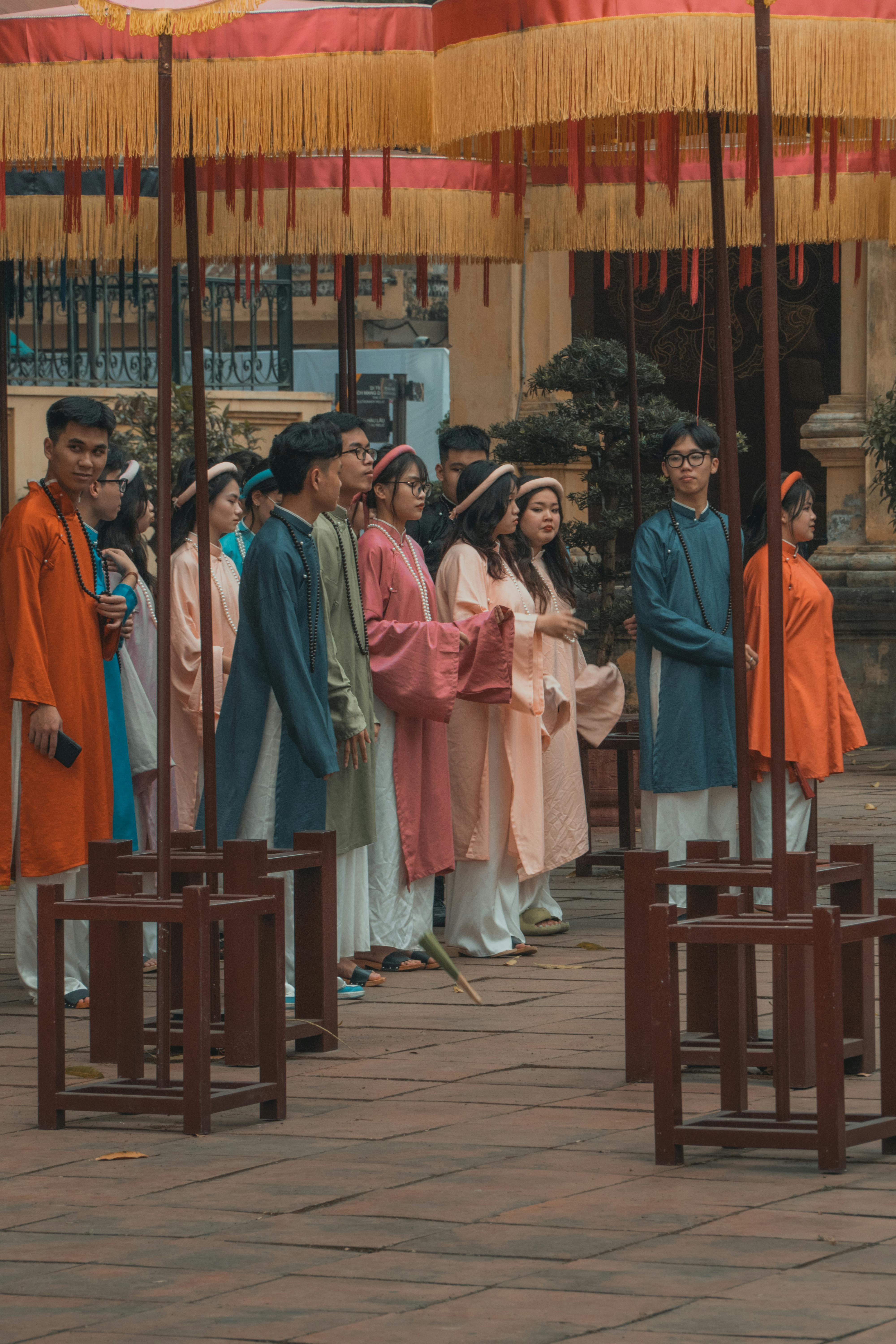 Miễn phí Các bạn trẻ trong trang phục truyền thống dưới những chiếc dù trong một buổi lễ sôi động của người Việt Nam. Ảnh lưu trữ