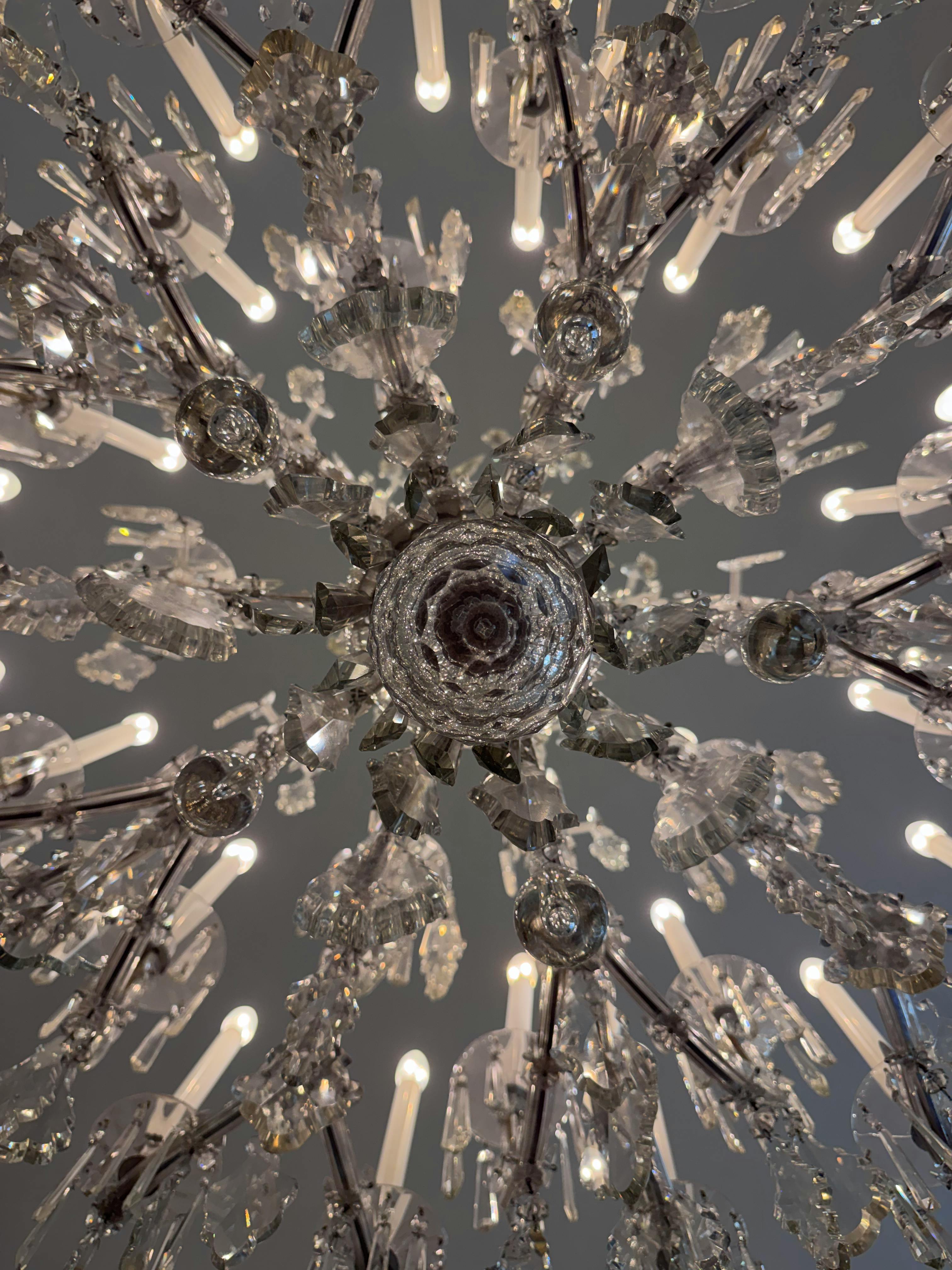 bezplatná Detailní pohled na zdobený křišťálový lustr s propracovanými detaily a odrazy světla. Základová fotografie