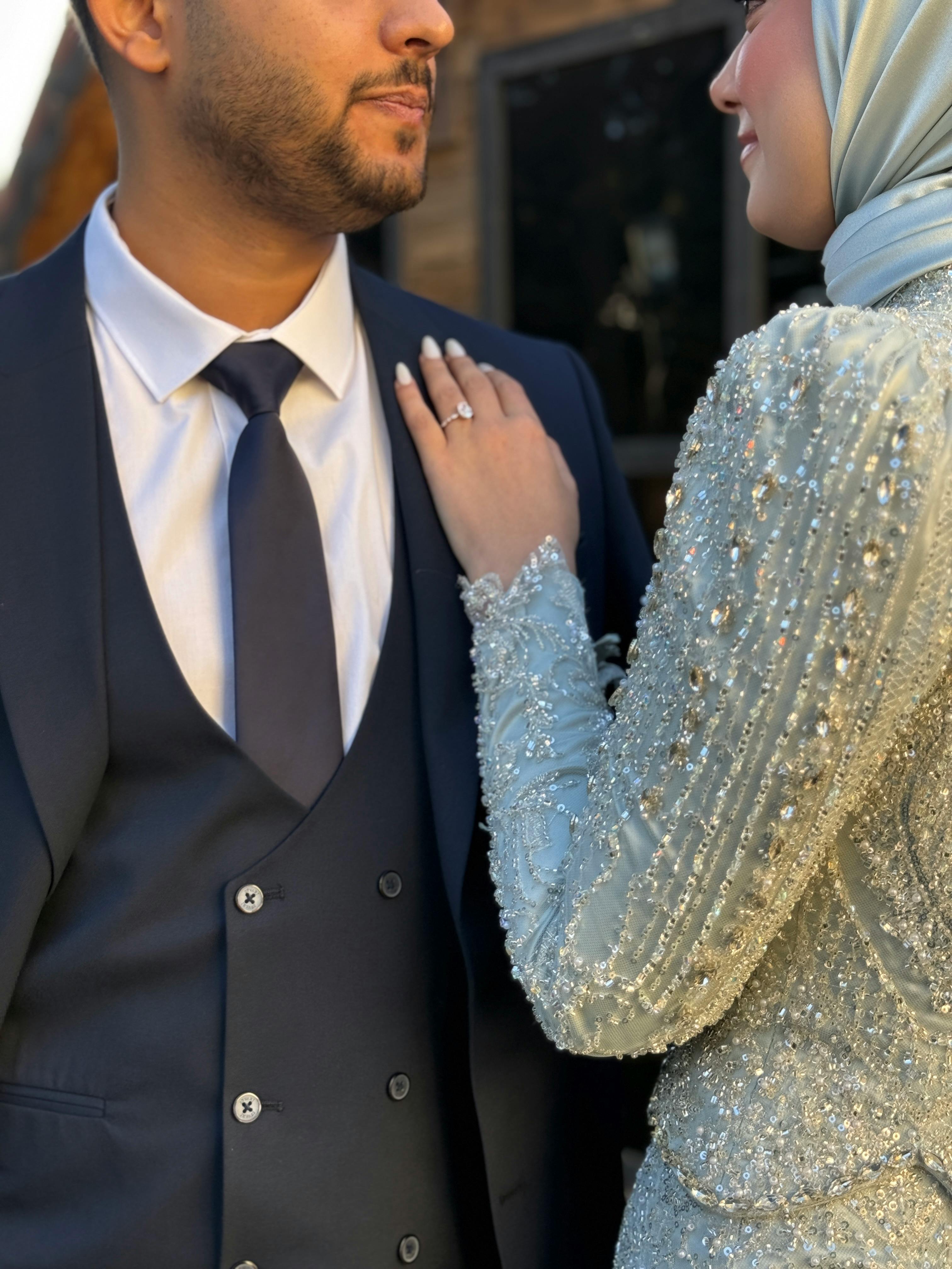 Miễn phí Một cặp đôi cưới trong trang phục thanh lịch đang ôm nhau ngoài trời vào ban ngày. Ảnh lưu trữ