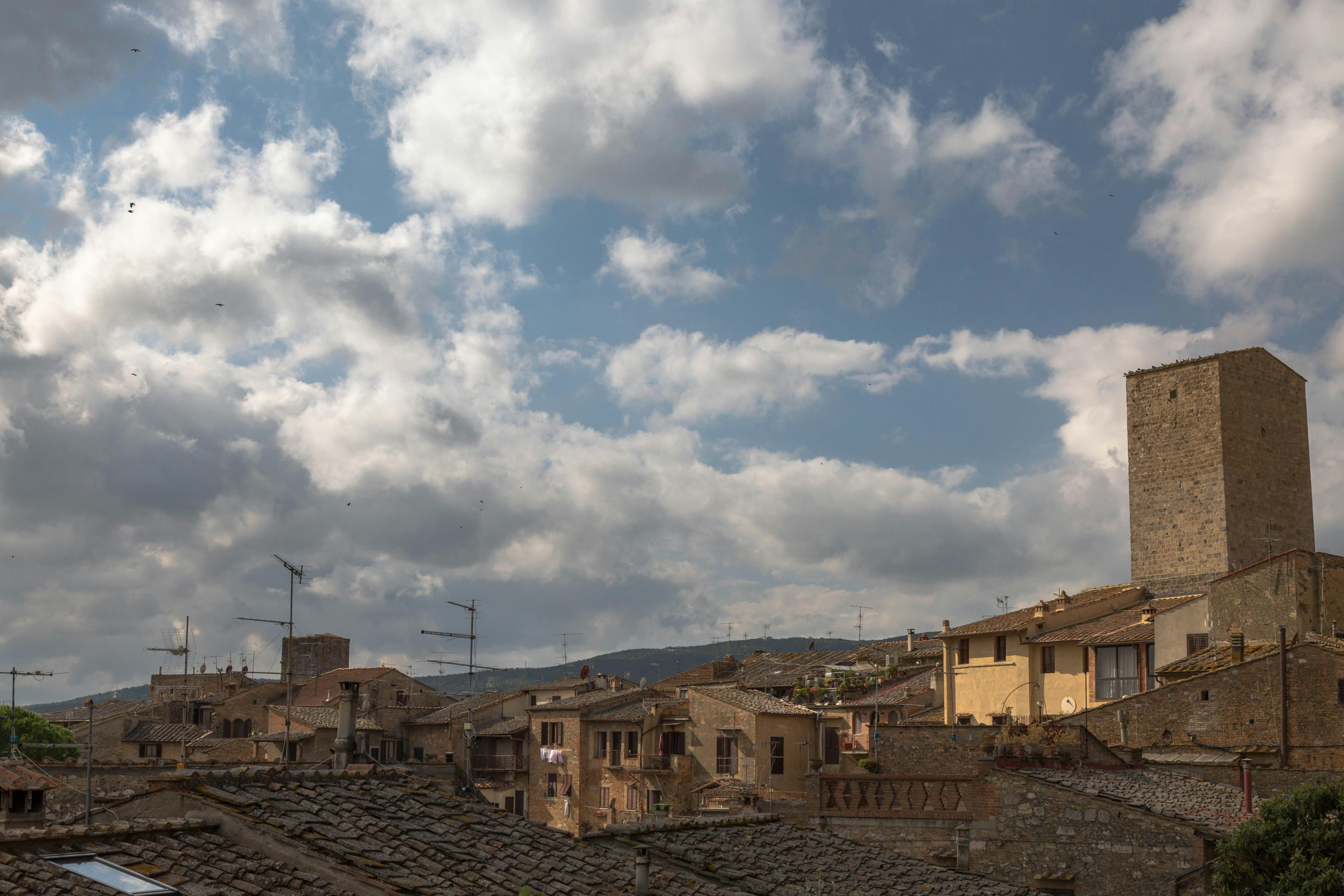Gratuit Une vue pittoresque sur une architecture historique en toiture, sous un ciel nuageux spectaculaire. Photos