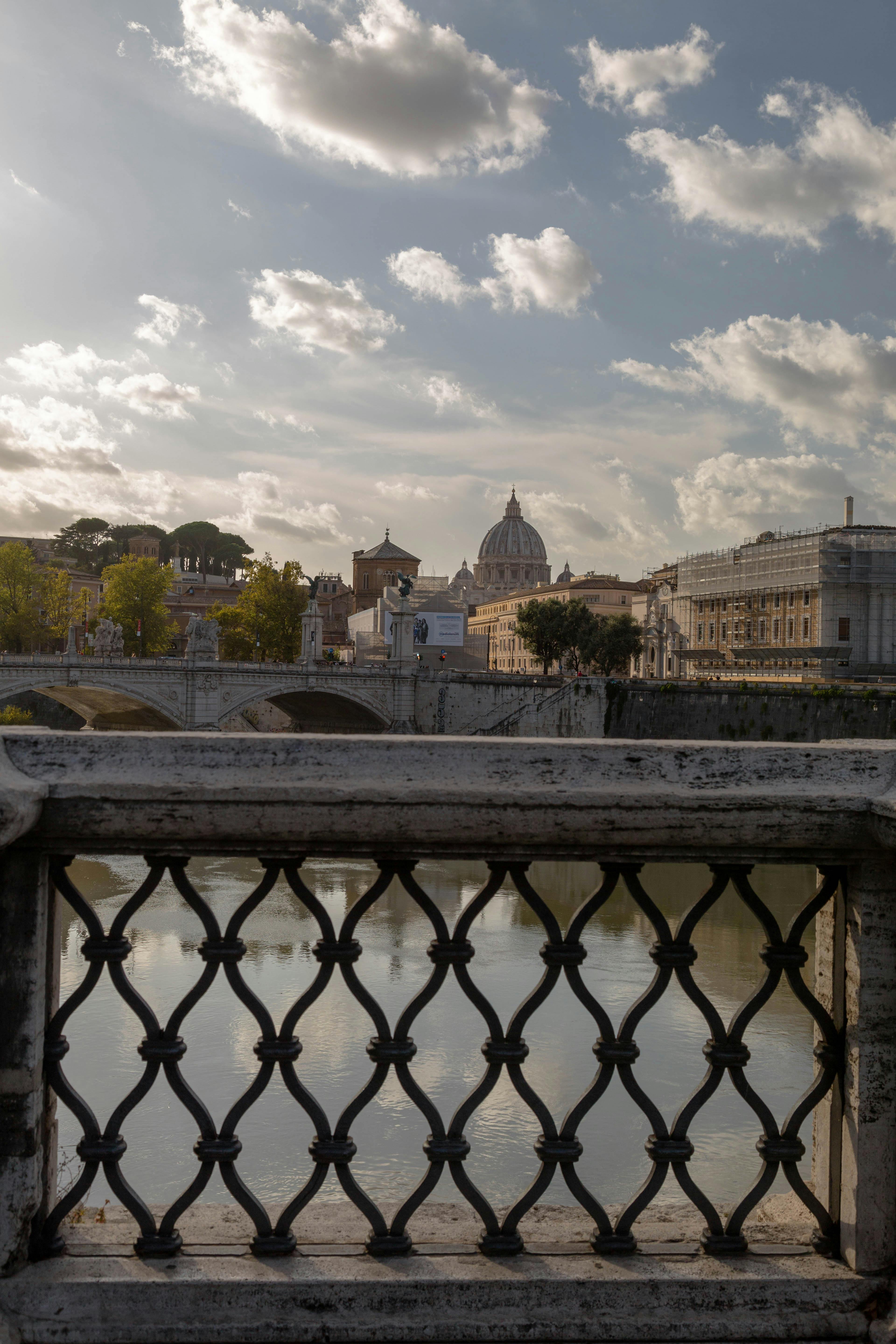 Miễn phí Cảnh quan Vương cung thánh đường Thánh Phêrô nhìn từ một cây cầu ở Rome, với kiến ​​trúc đẹp như tranh vẽ và dòng sông yên bình. Ảnh lưu trữ