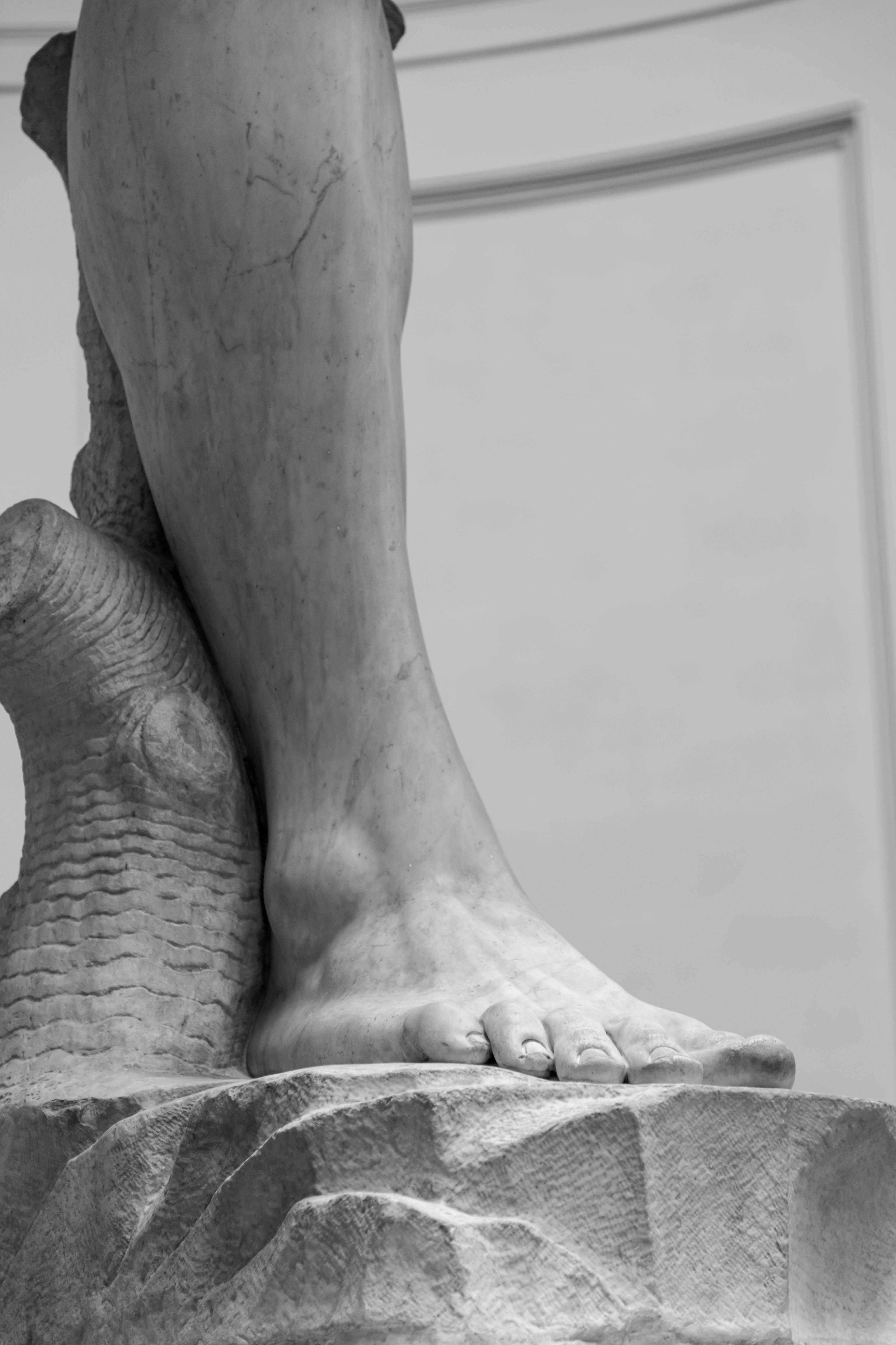 ฟรี ภาพถ่ายขาวดำรายละเอียดสูงของขาของรูปปั้นหินอ่อน เน้นมุมมองทางศิลปะ คลังภาพถ่าย