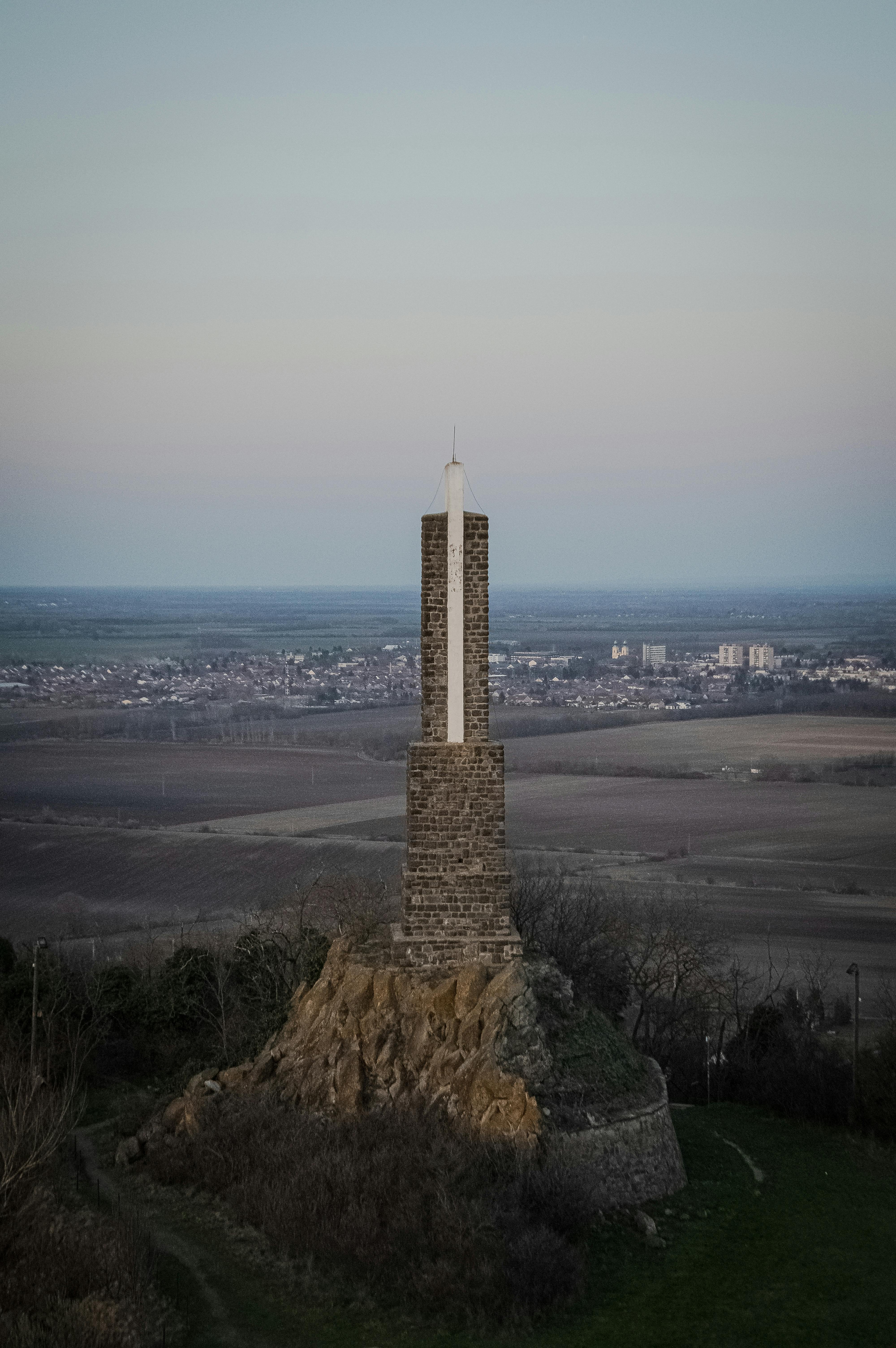 Miễn phí Tượng đài bằng đá có thánh giá trên đỉnh, nhìn ra khung cảnh nông thôn rộng lớn lúc hoàng hôn. Ảnh lưu trữ