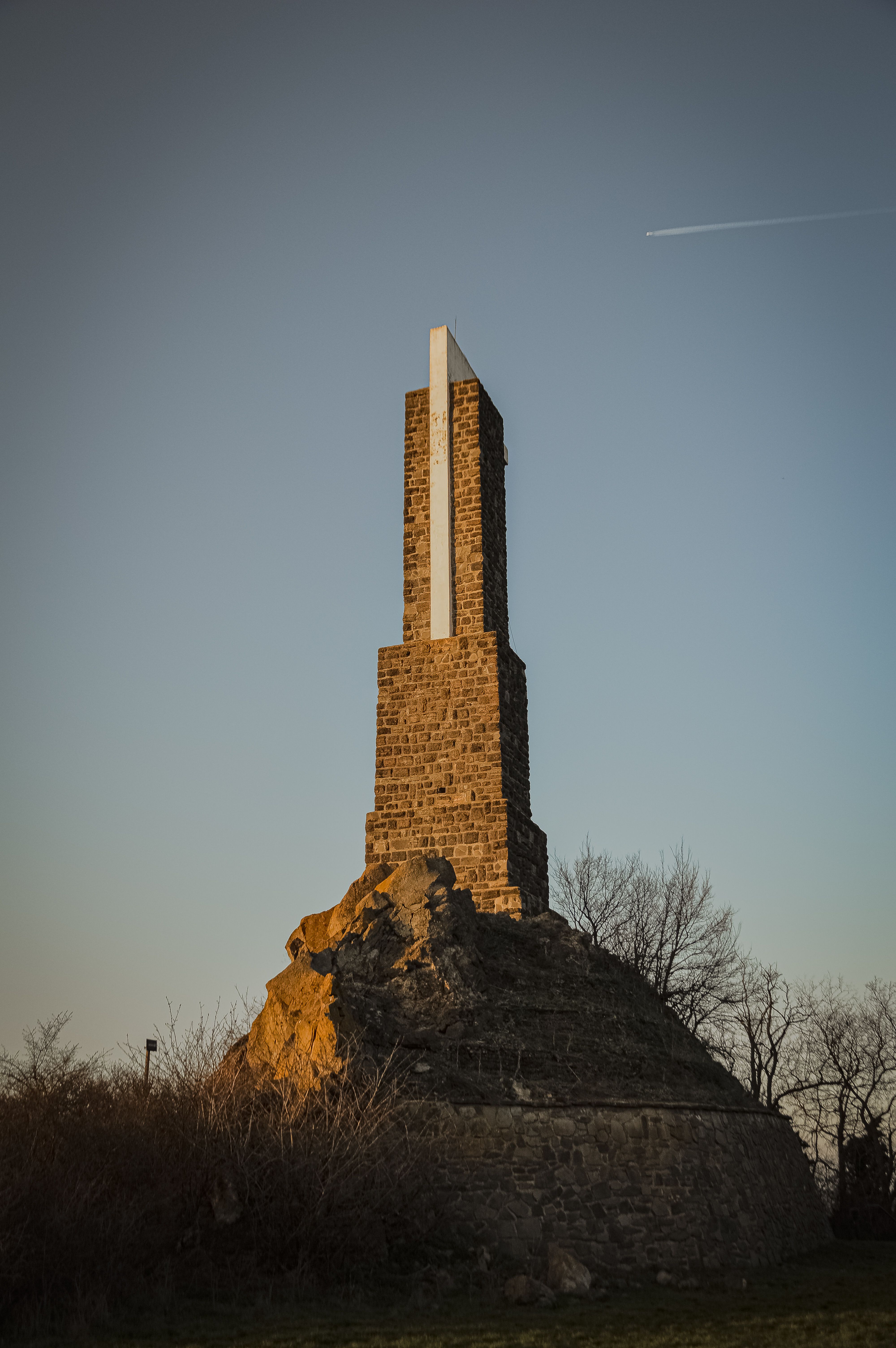 A striking stone monument towers against a serene sunset sky, capturing the peaceful ambiance of nature.