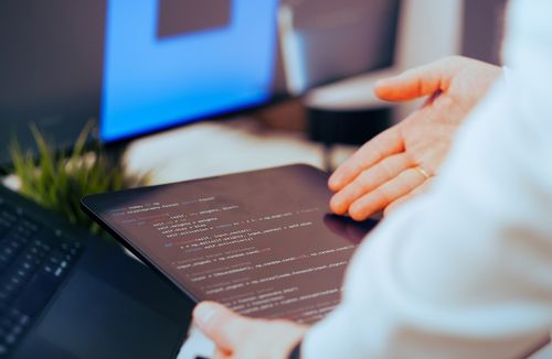 Reviewing AI-assisted work on a tablet alongside a laptop and monitor