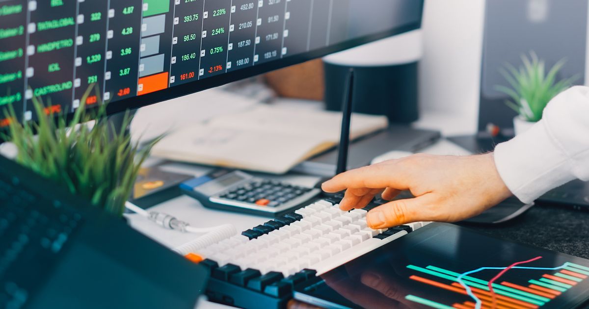 Professional workspace with trading charts and market data on screens, ideal for finance and investment contexts.