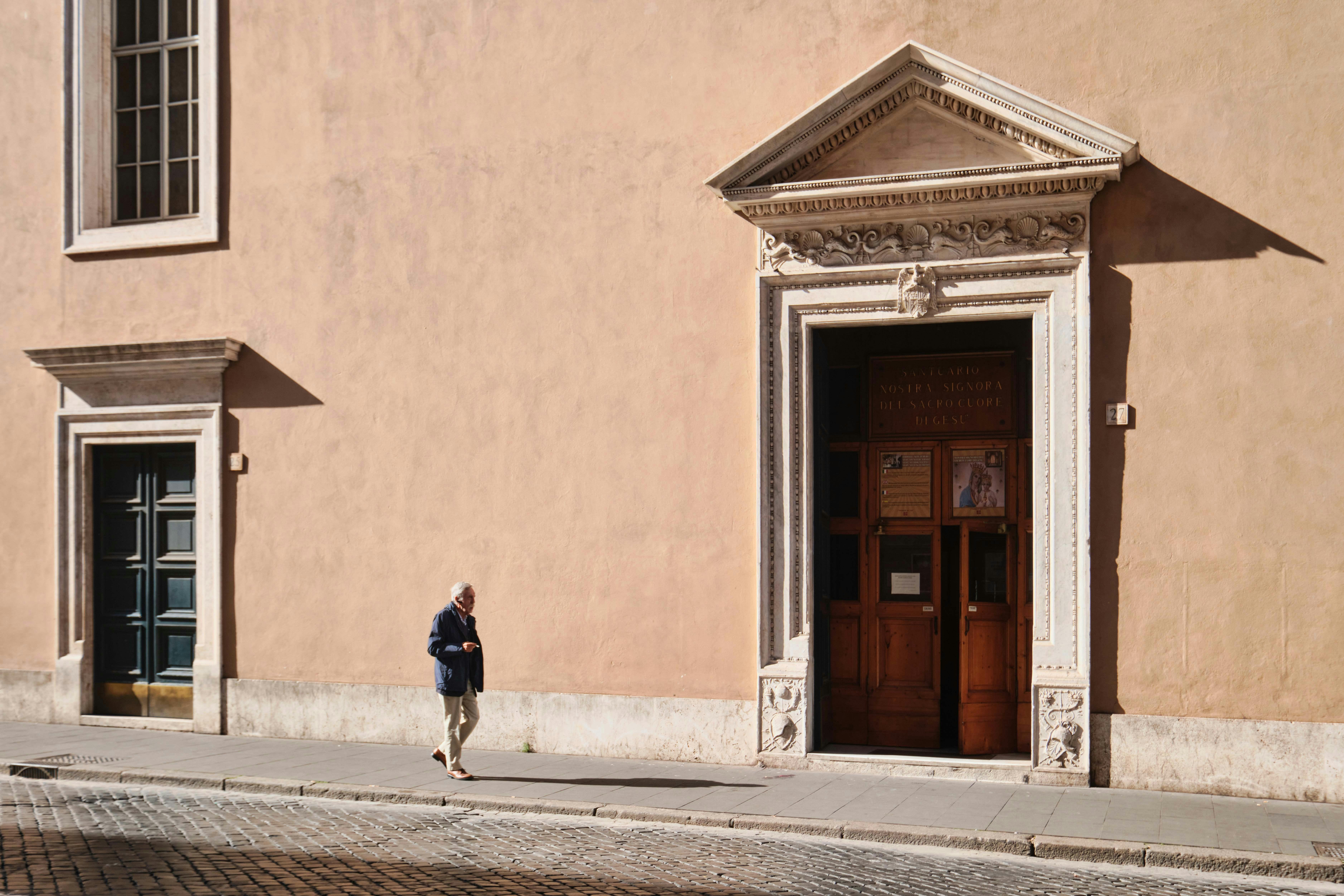 Zadarmo Senior prechádza okolo historickej architektúry na slnečnej ulici v Ríme v Taliansku. Fotka z fotobanky