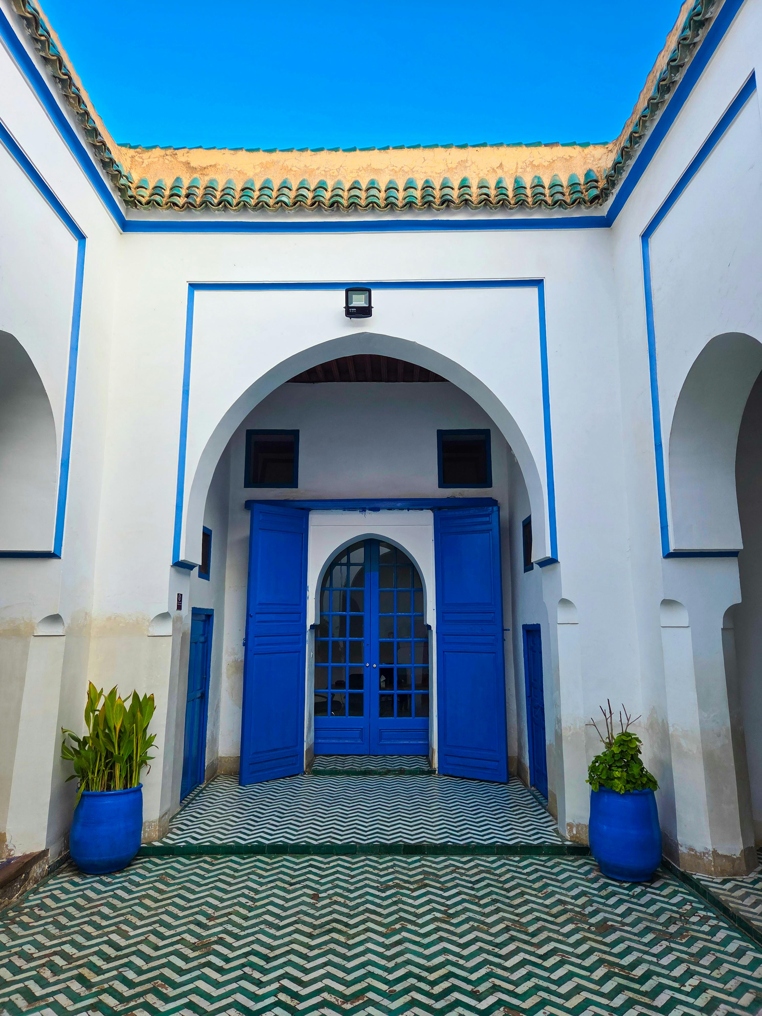 Gratuit Une cour intérieure aux couleurs bleu et blanc éclatantes à Marrakech met en valeur l'architecture marocaine classique. Photos
