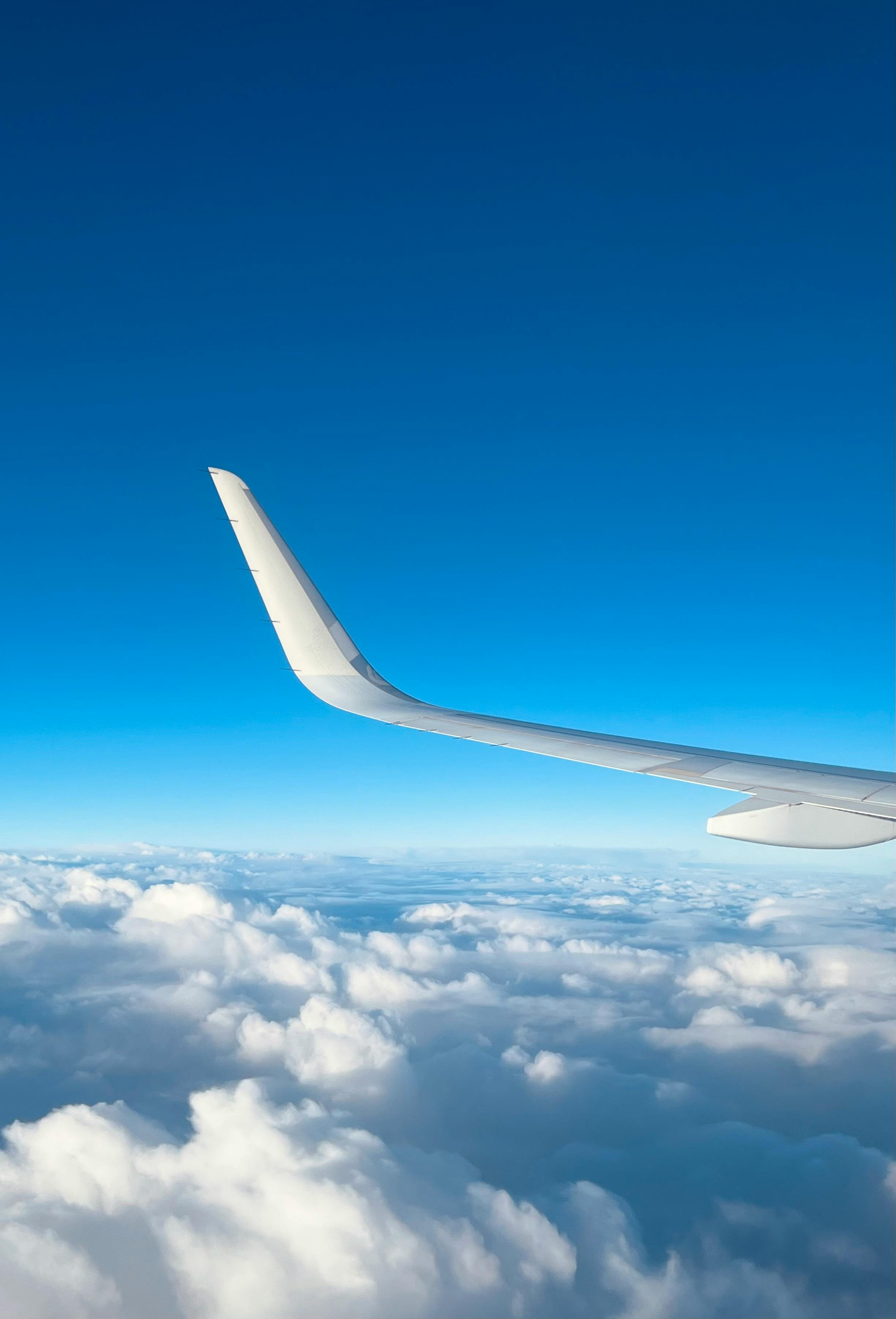 免费 从飞机机翼上看到的晴朗蓝天和朵朵白云。 素材图片