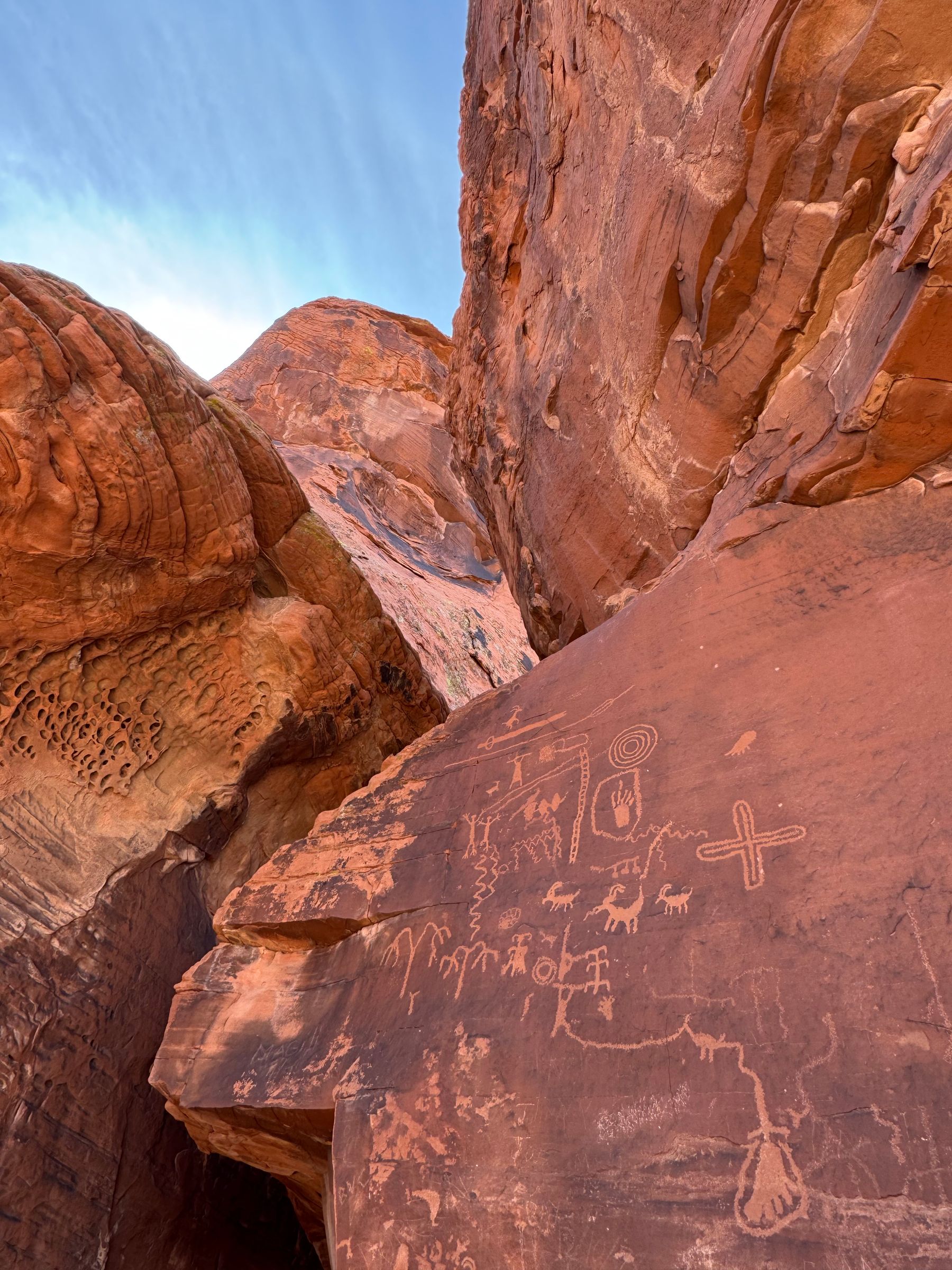 Ancient petroglyphs etched into red sandstone canyon walls in Moapa Valley, Nevada.