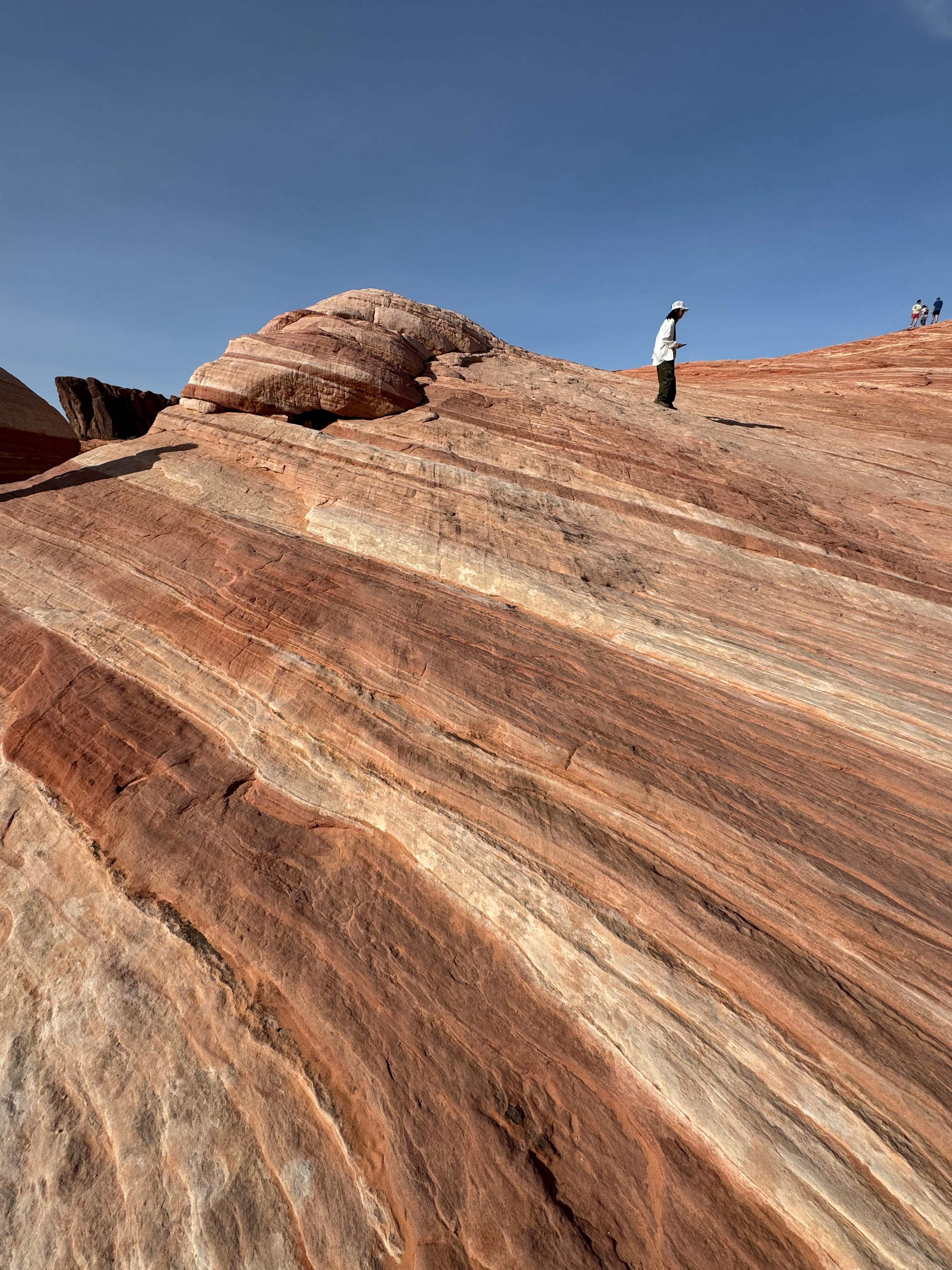 Miễn phí Một người leo núi đơn độc đứng trên đỉnh những khối đá sa thạch rực rỡ sắc màu tại Công viên tiểu bang Valley of Fire, Nevada. Ảnh lưu trữ