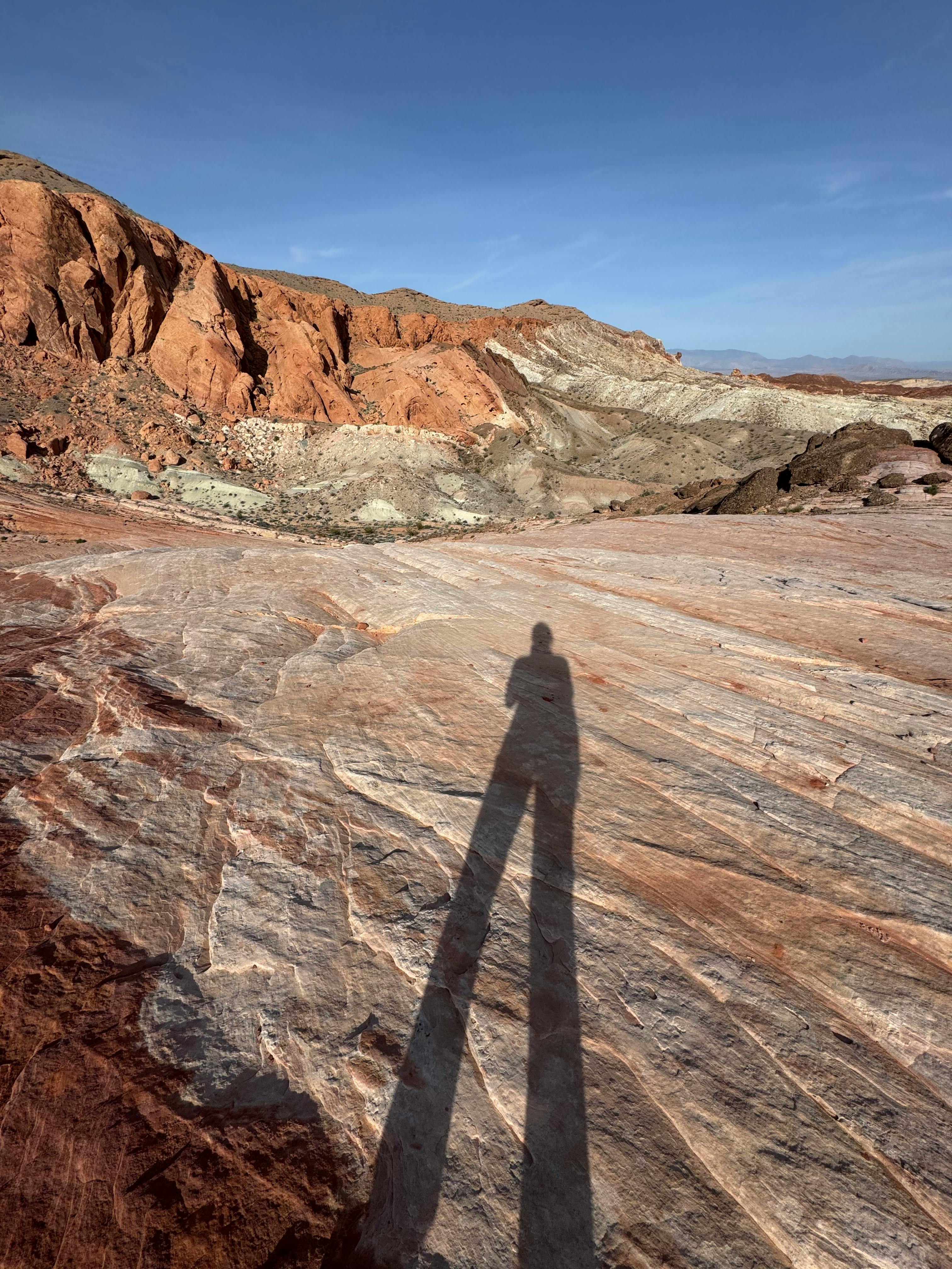 Free Long shadow silhouette cast on vibrant rock formations in Moapa Valley, showcasing the area's natural beauty. Stock Photo