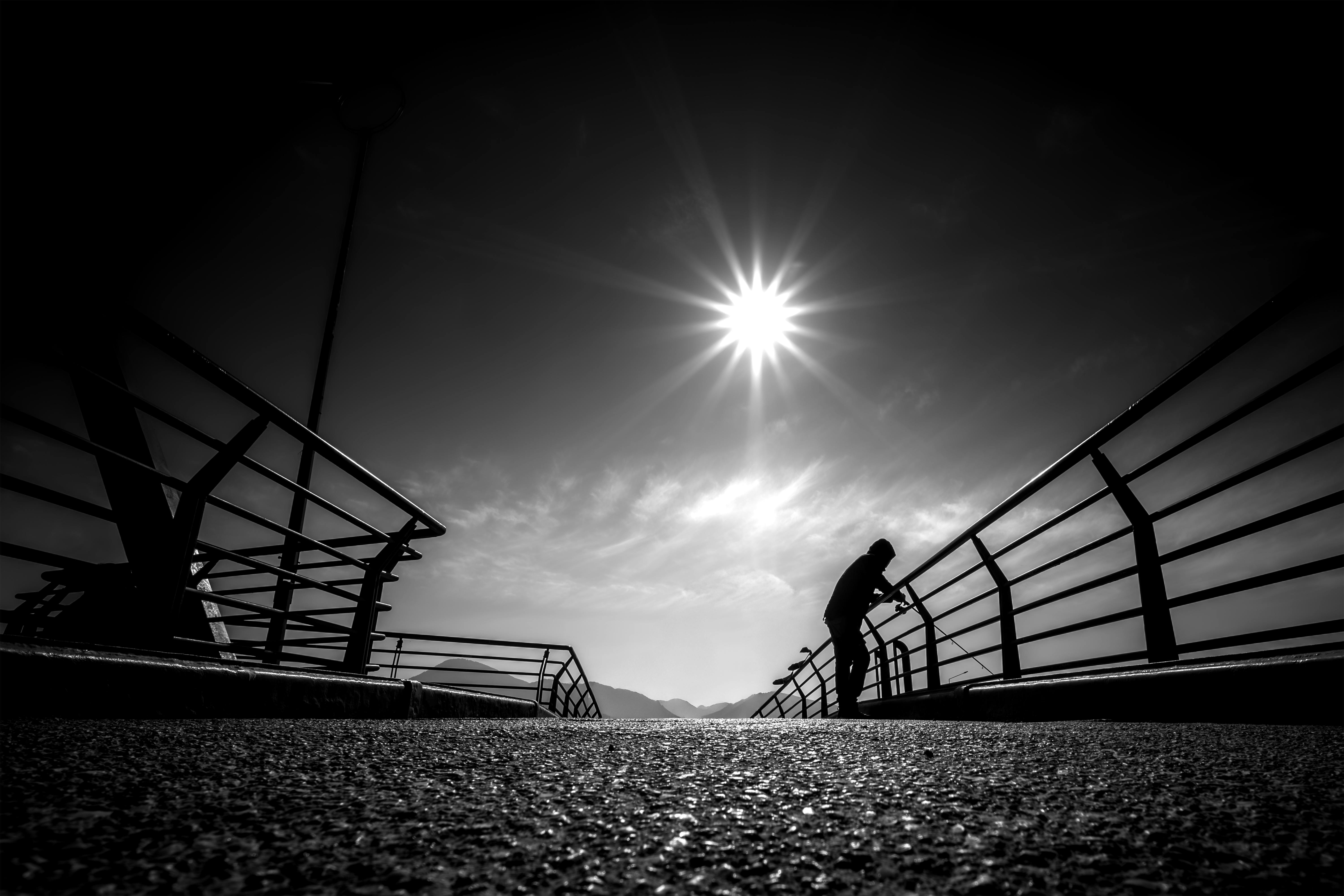 ฟรี ภาพเงาขาวดำของบุคคลบนสะพานในเมืองอิซมีร์ ประเทศตุรกี ภายใต้แสงแดดจ้า คลังภาพถ่าย