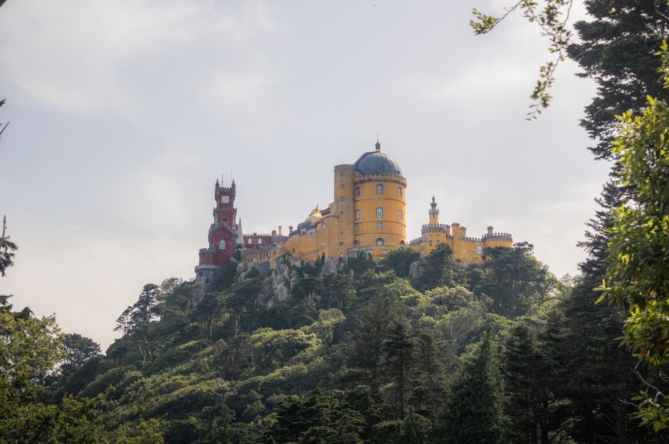 The vibrant Pena Palace in <span class="notranslate"><em>Sintra</em></span>, surrounded by lush gardens and misty hills.