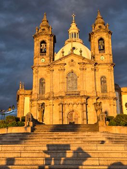 The majestic Bom Jesus do Monte Sanctuary in Braga, Portugal, illuminated by a golden sunset.